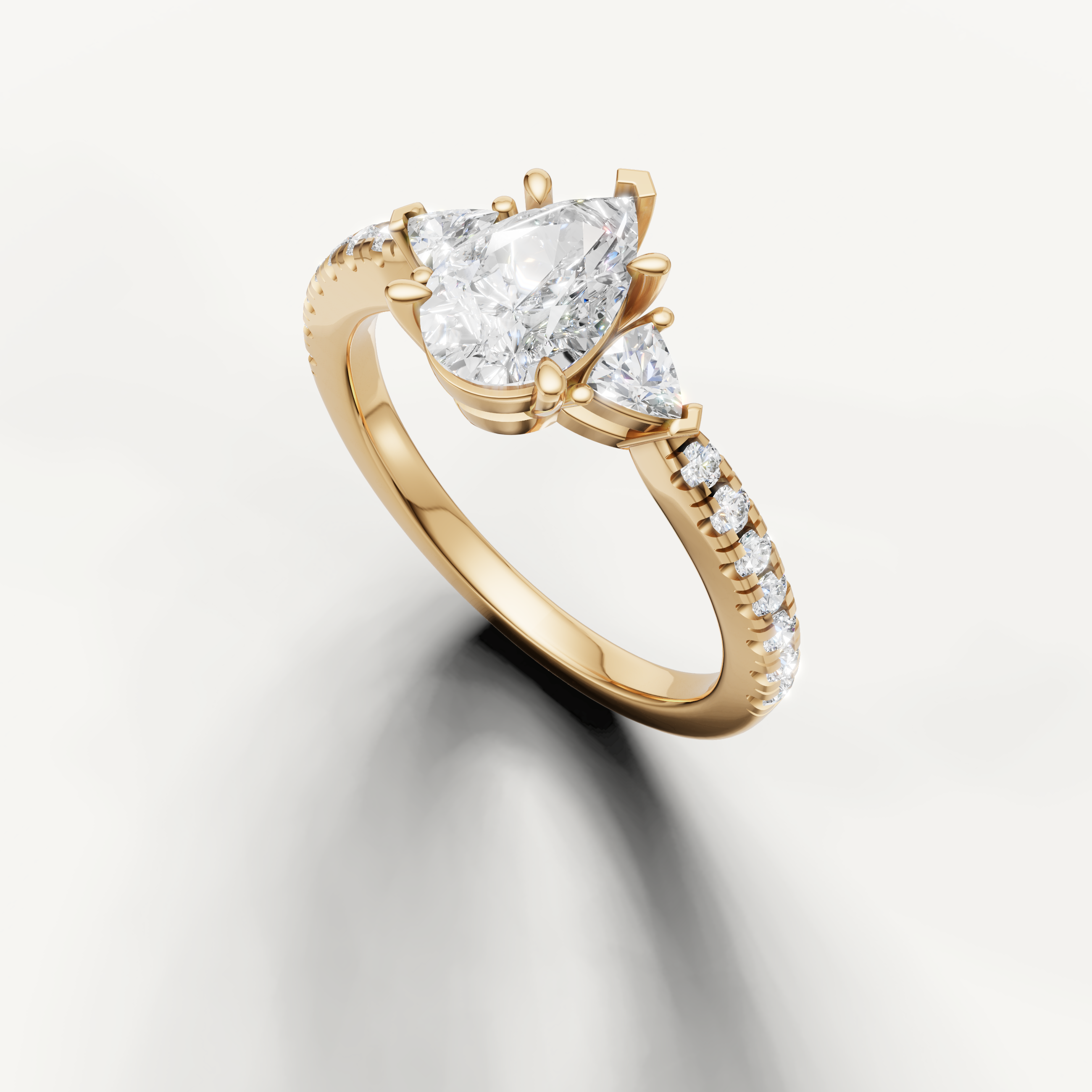 Pear cut three-stone lab grown diamond ring in yellow gold with slim pavé band