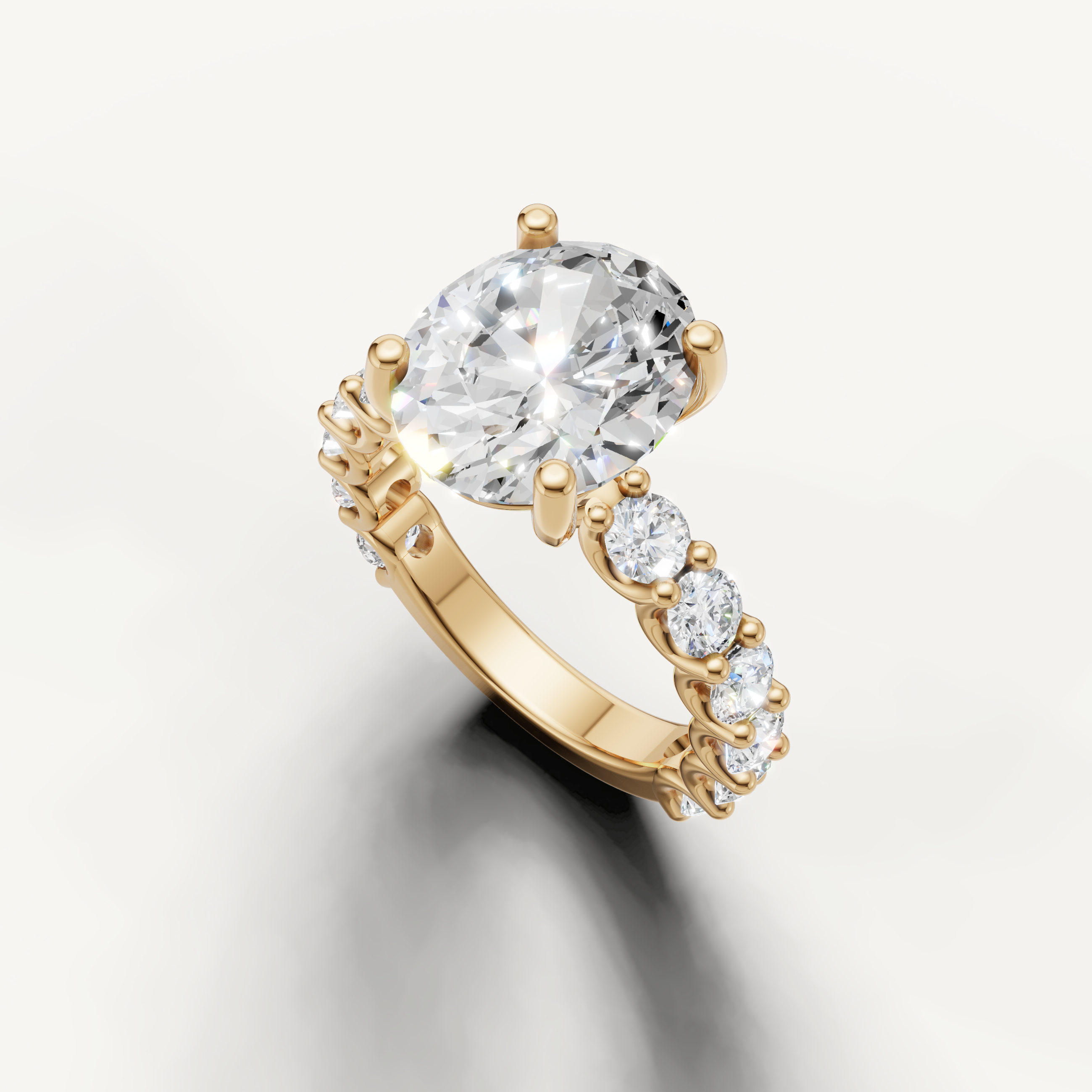 Oval diamond solitaire ring with graduated side stones in yellow gold