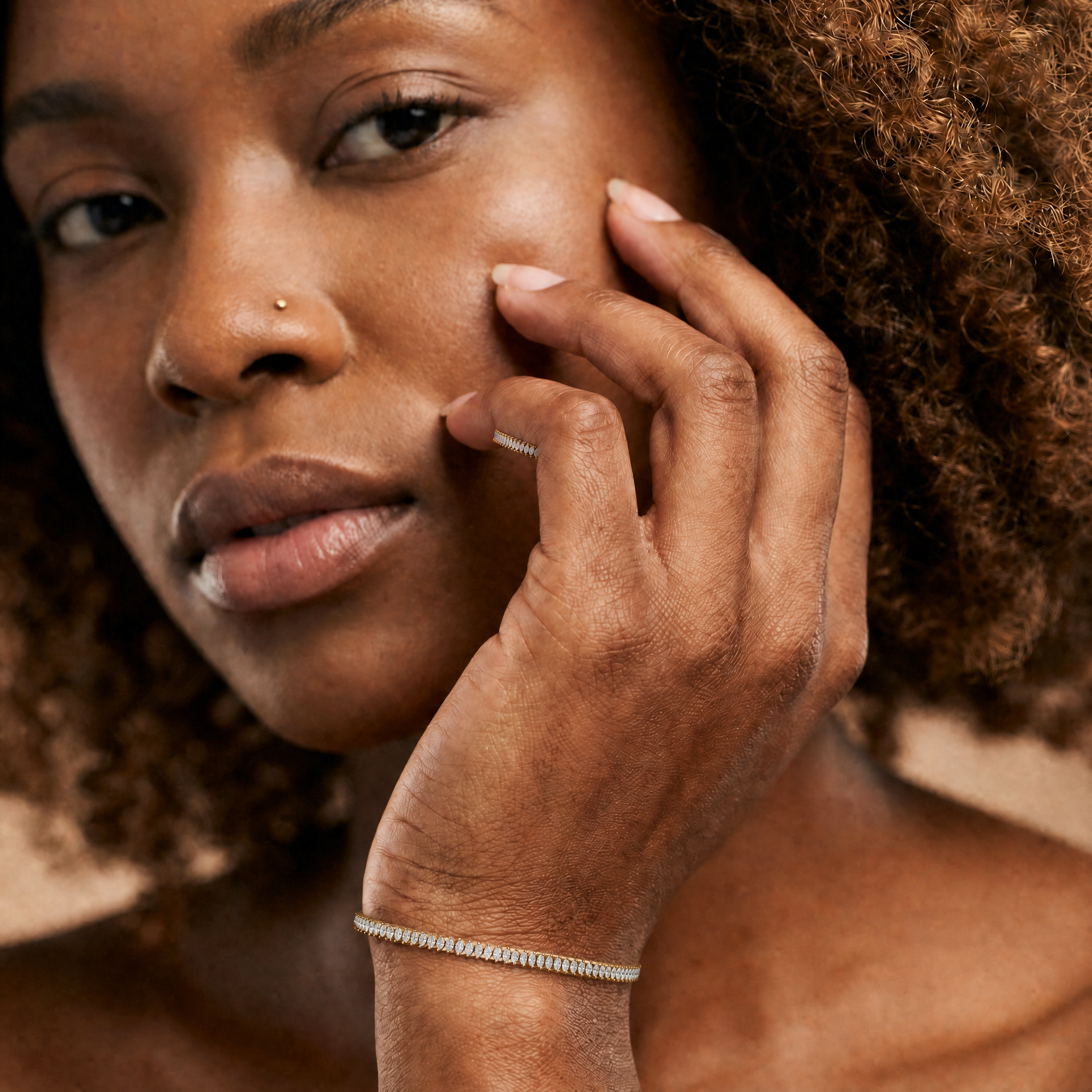 Elegant female model wearing a yellow gold marquise lab grown diamond tennis bracelet by Raul Diamonds featuring elongated diamond shapes and luxurious fine jewelry styling