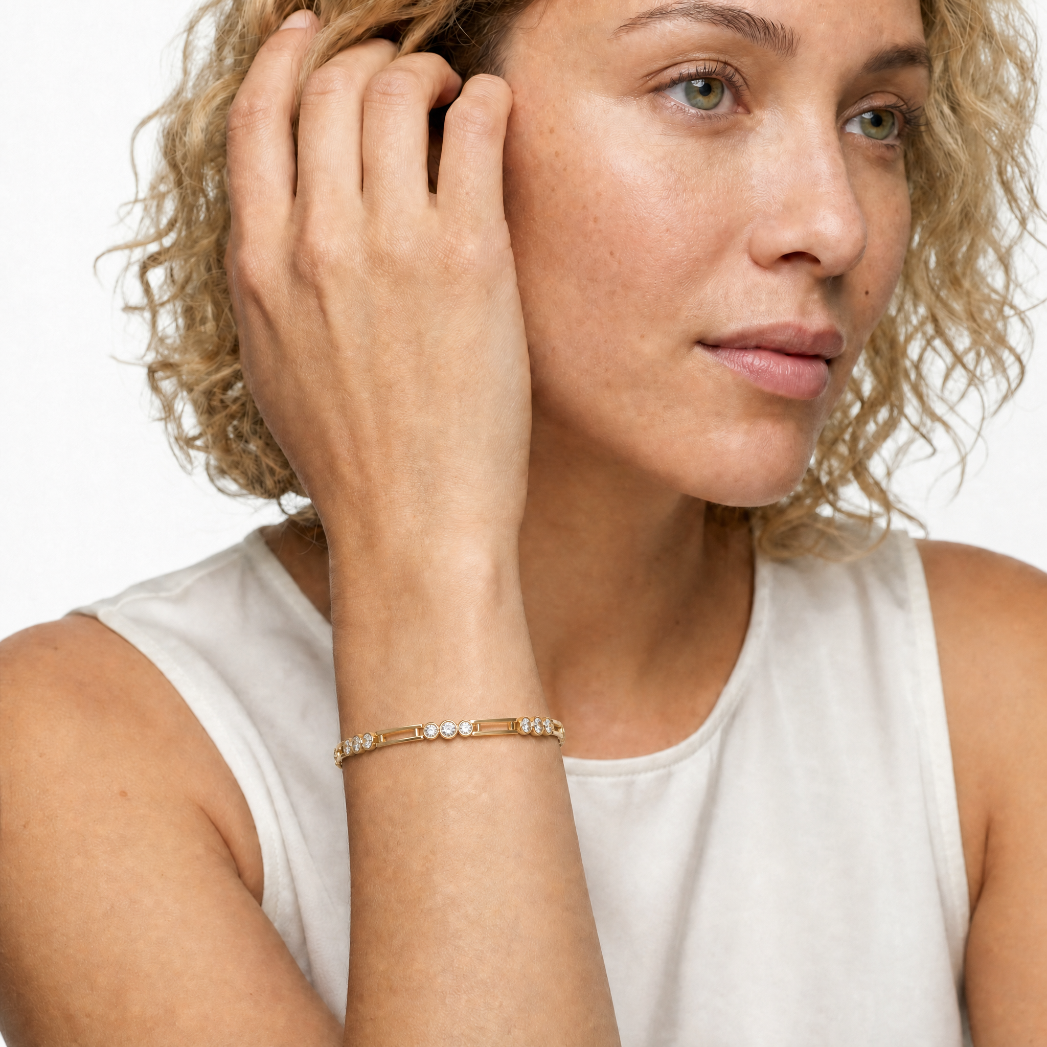 Luxury female model wearing a modern yellow gold lab grown diamond bracelet by Raul Diamonds featuring elegant round diamonds and contemporary fine jewelry styling
