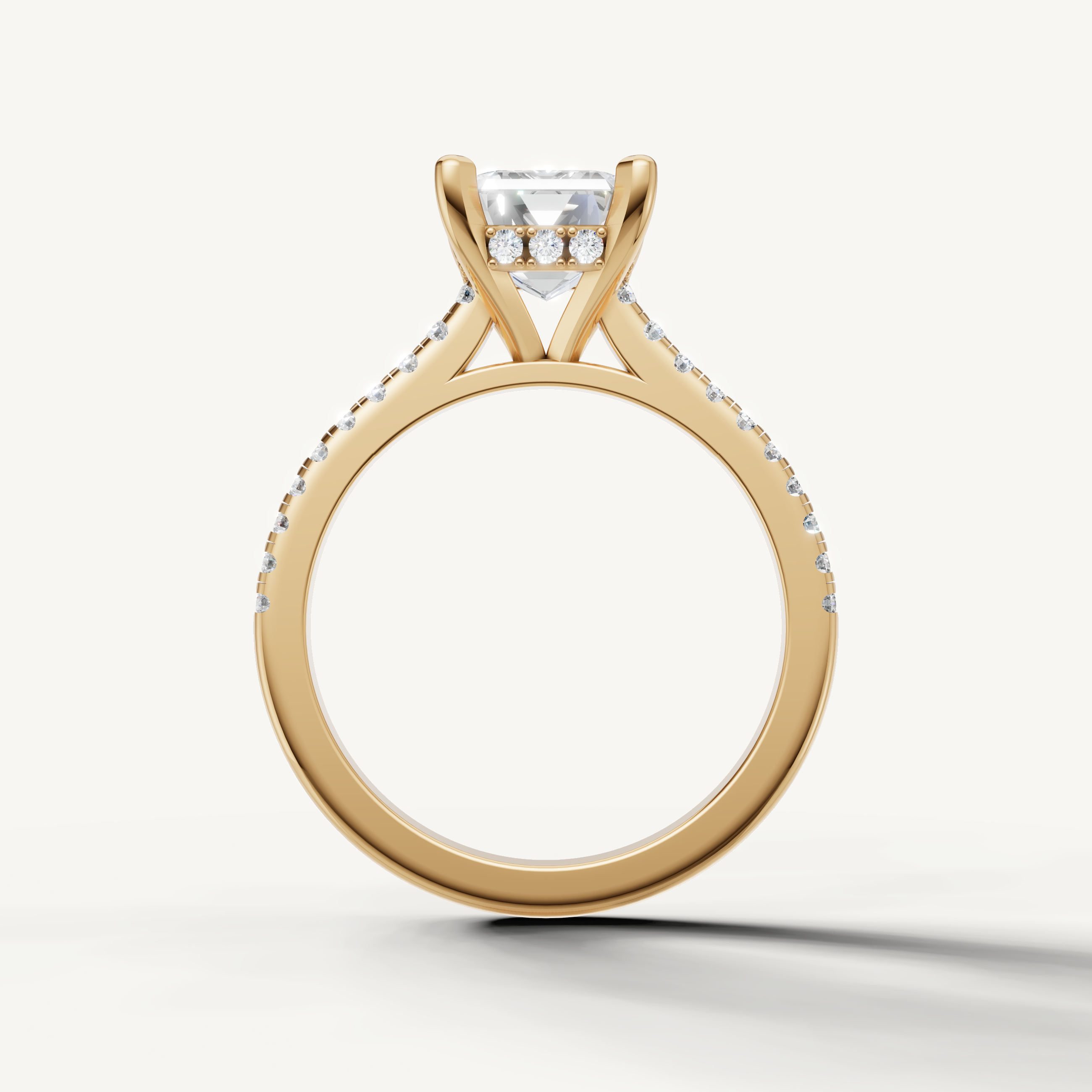 Elegant emerald cut lab grown diamond ring with tapered pavé band in yellow gold