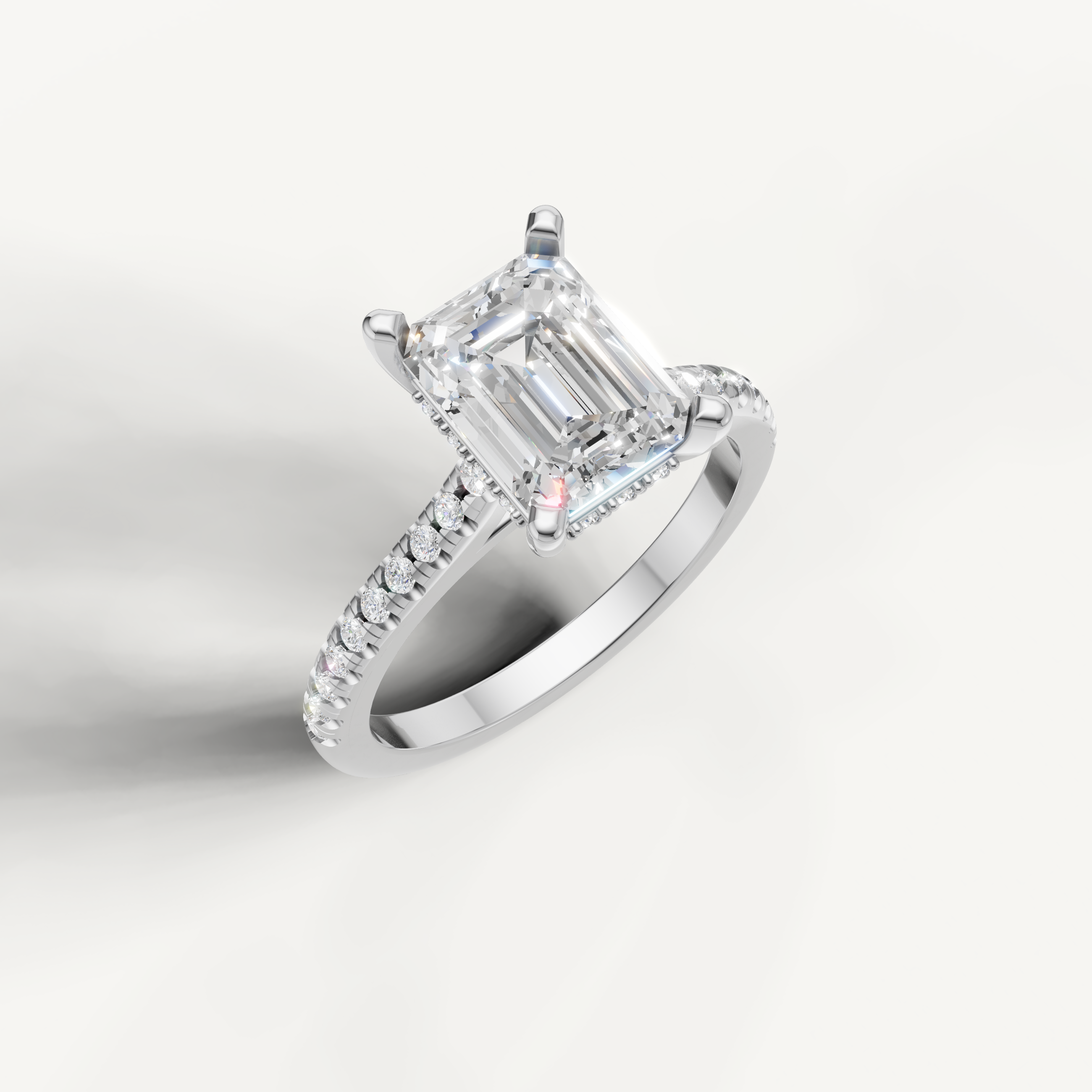 White gold emerald cut diamond solitaire ring with pavé band detail