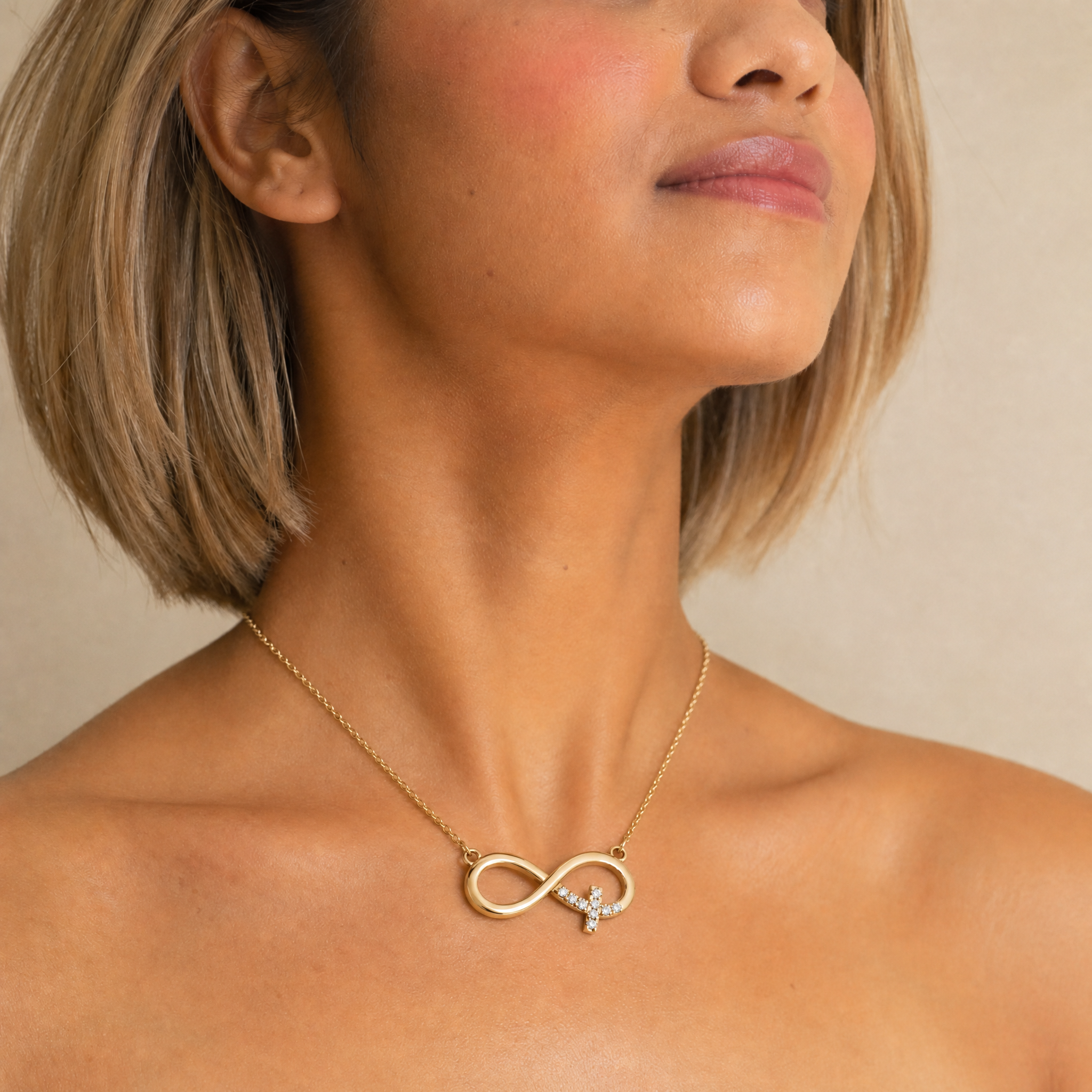 Female Model Wearing Infinity Symbol Initial Pendant Necklace in 14K Gold by Raul Diamonds