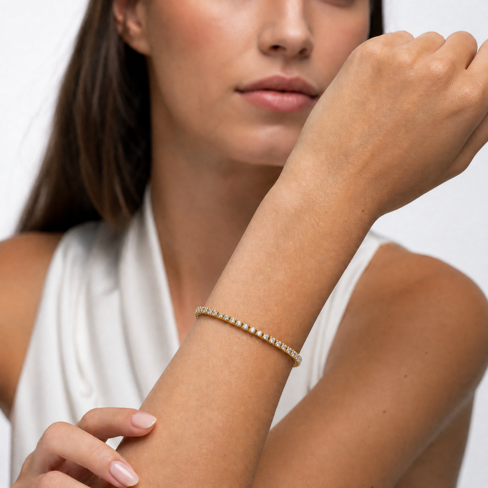 Elegant female model wearing a classic lab grown diamond tennis bracelet in yellow gold by Raul Diamonds featuring timeless fine jewelry elegance and luxurious modern craftsmanship