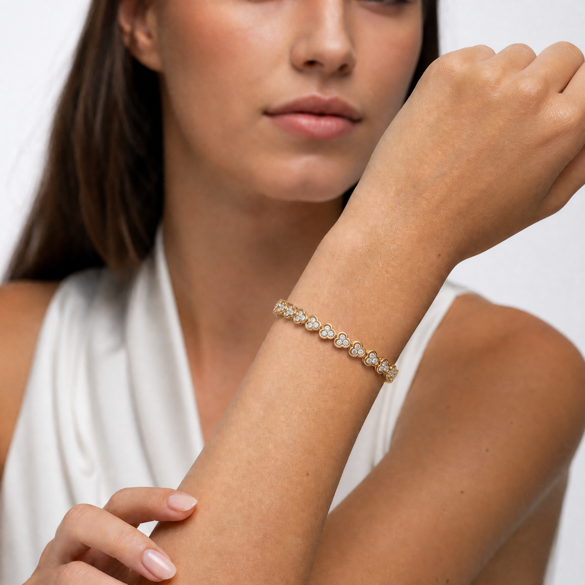 Luxury female model wearing a clover inspired lab grown diamond bracelet in yellow gold by Raul Diamonds featuring elegant fine jewelry craftsmanship and timeless modern style