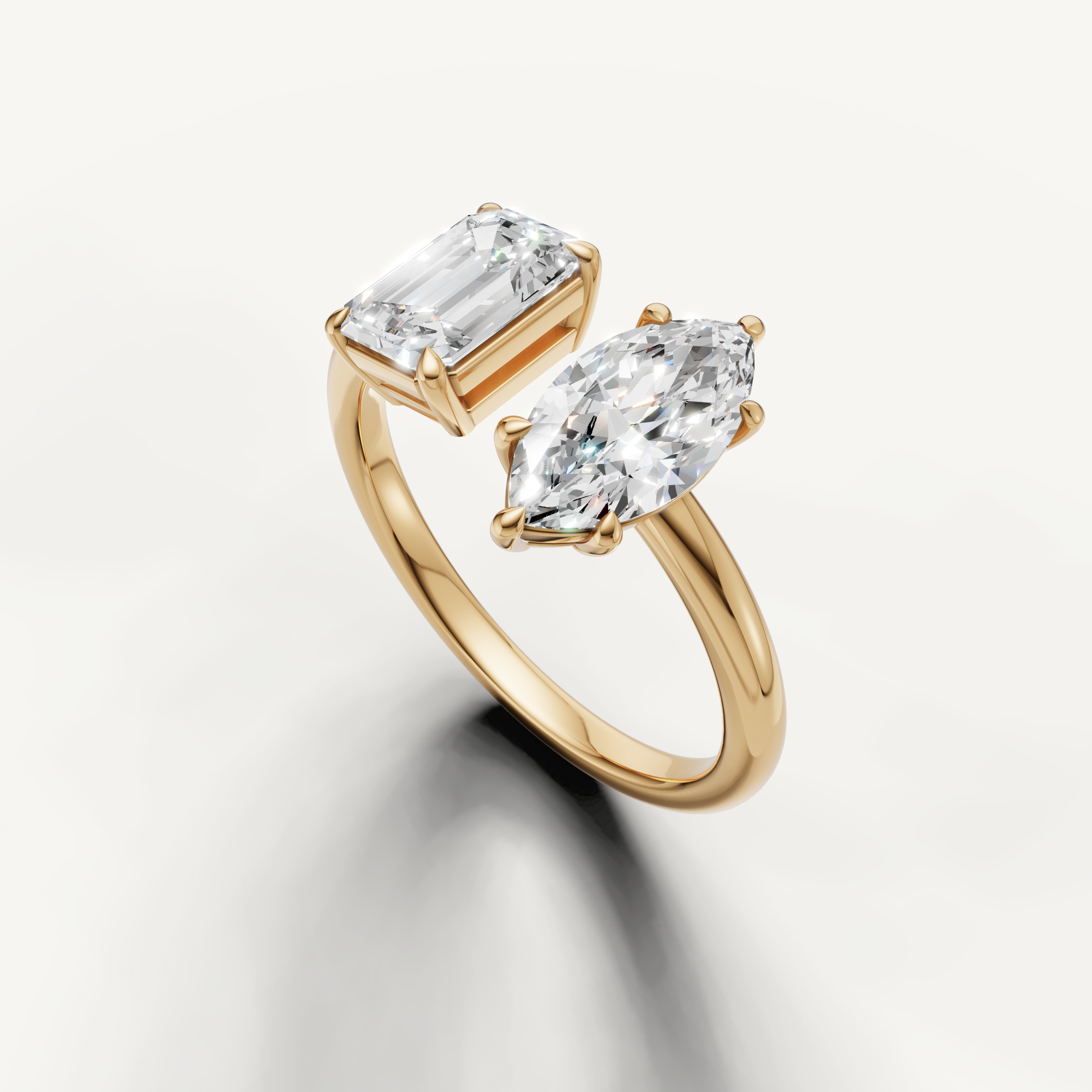 Elegant yellow gold two stone engagement ring with marquise and emerald cut diamonds from Raul Diamonds