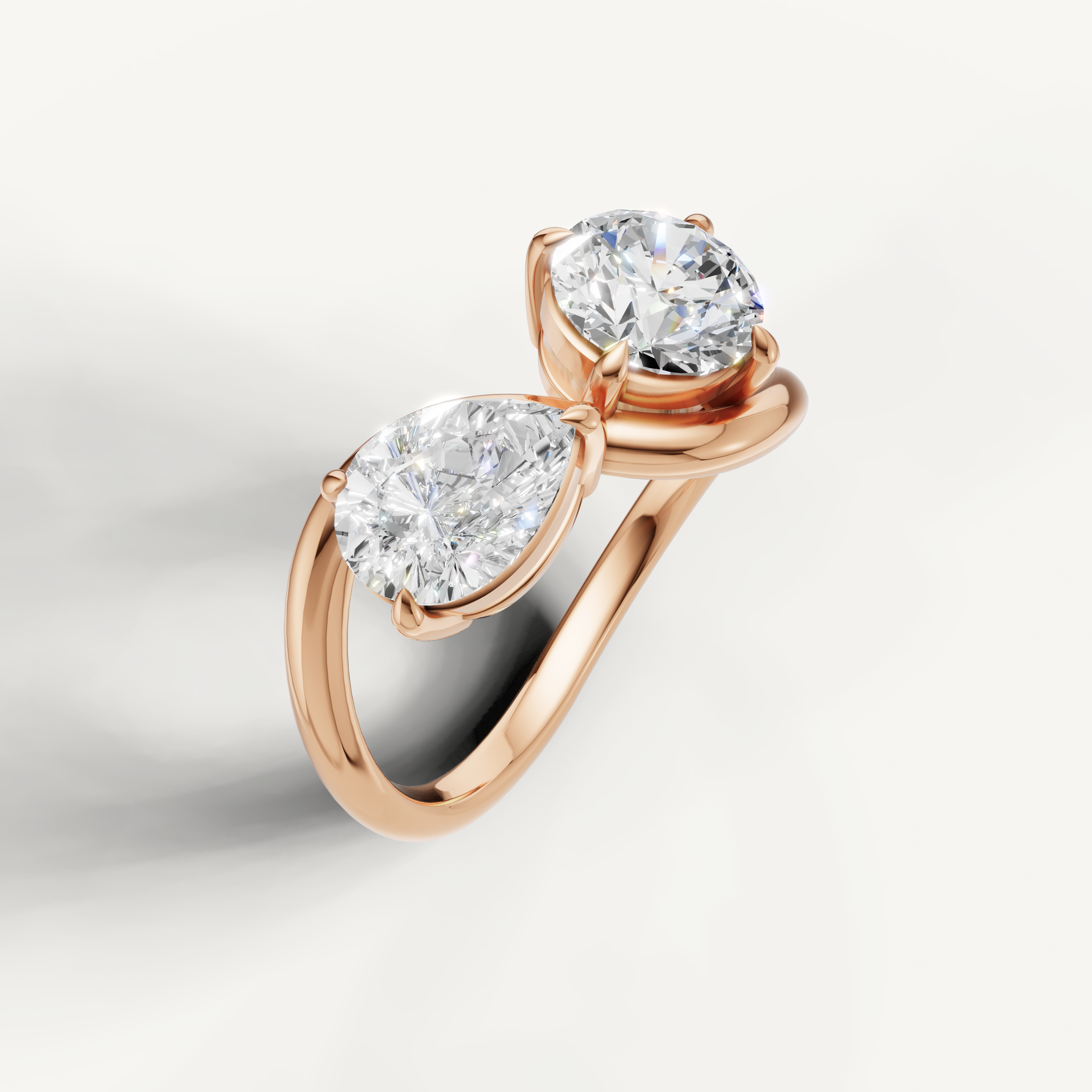 Romantic rose gold dual stone diamond ring featuring pear and round brilliant diamonds