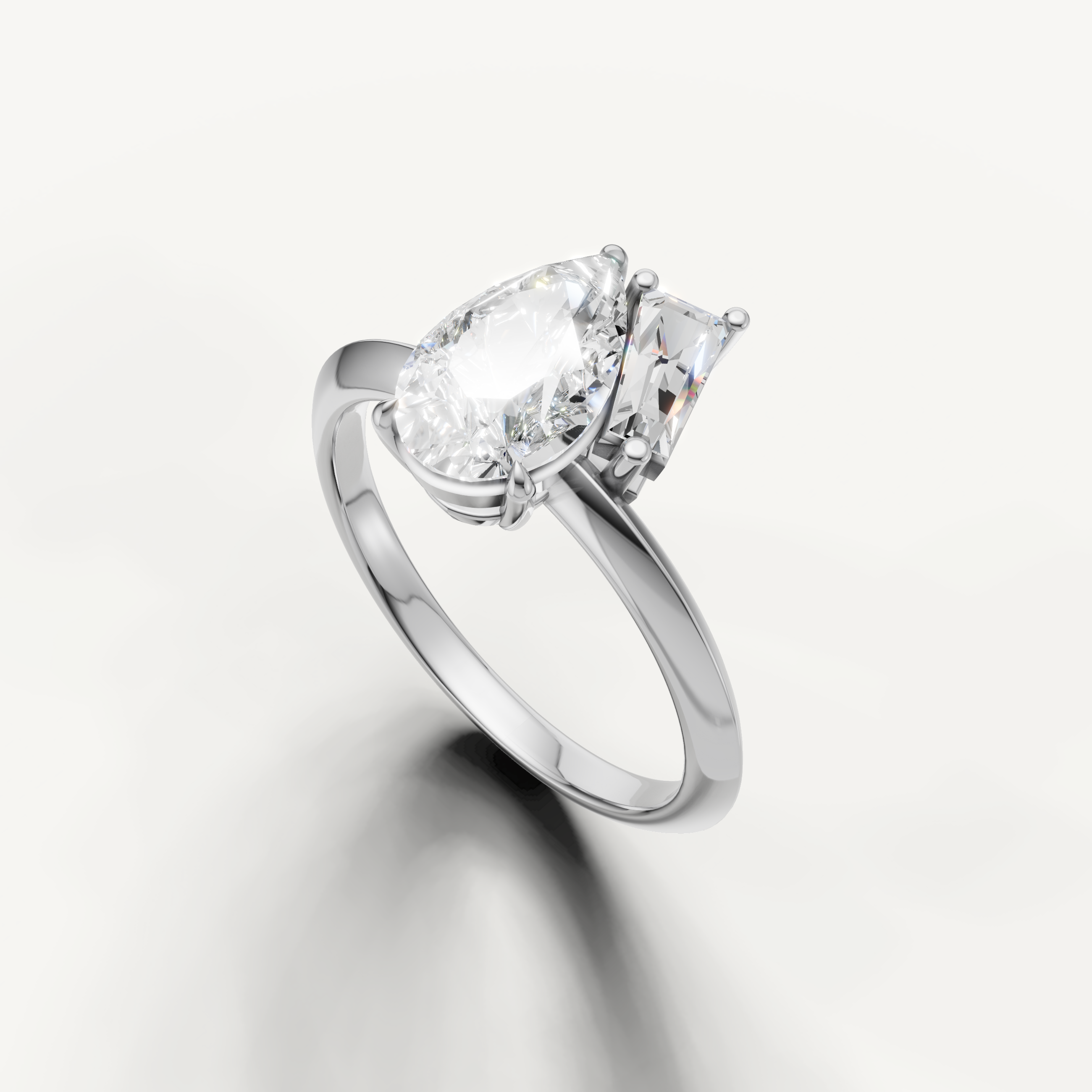 Luxury white gold dual stone engagement ring with pear and trapezoid diamonds from Raul Diamonds