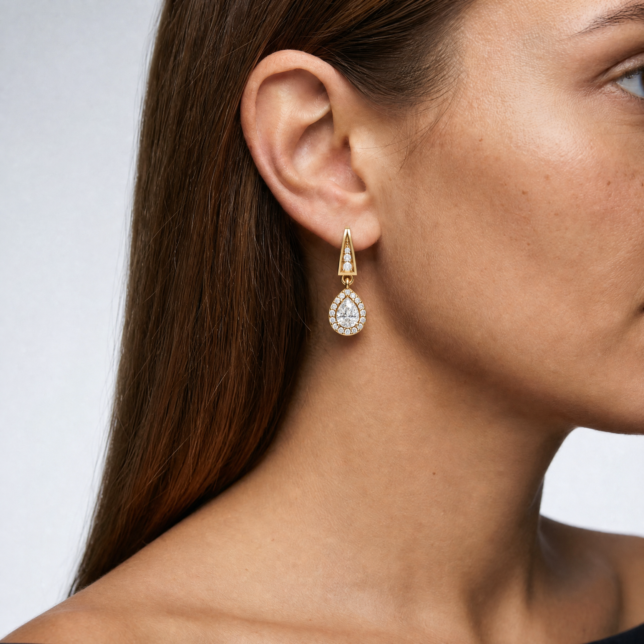 Elegant model wearing Raul Diamonds pear shape halo diamond drop earrings with luxurious sparkle