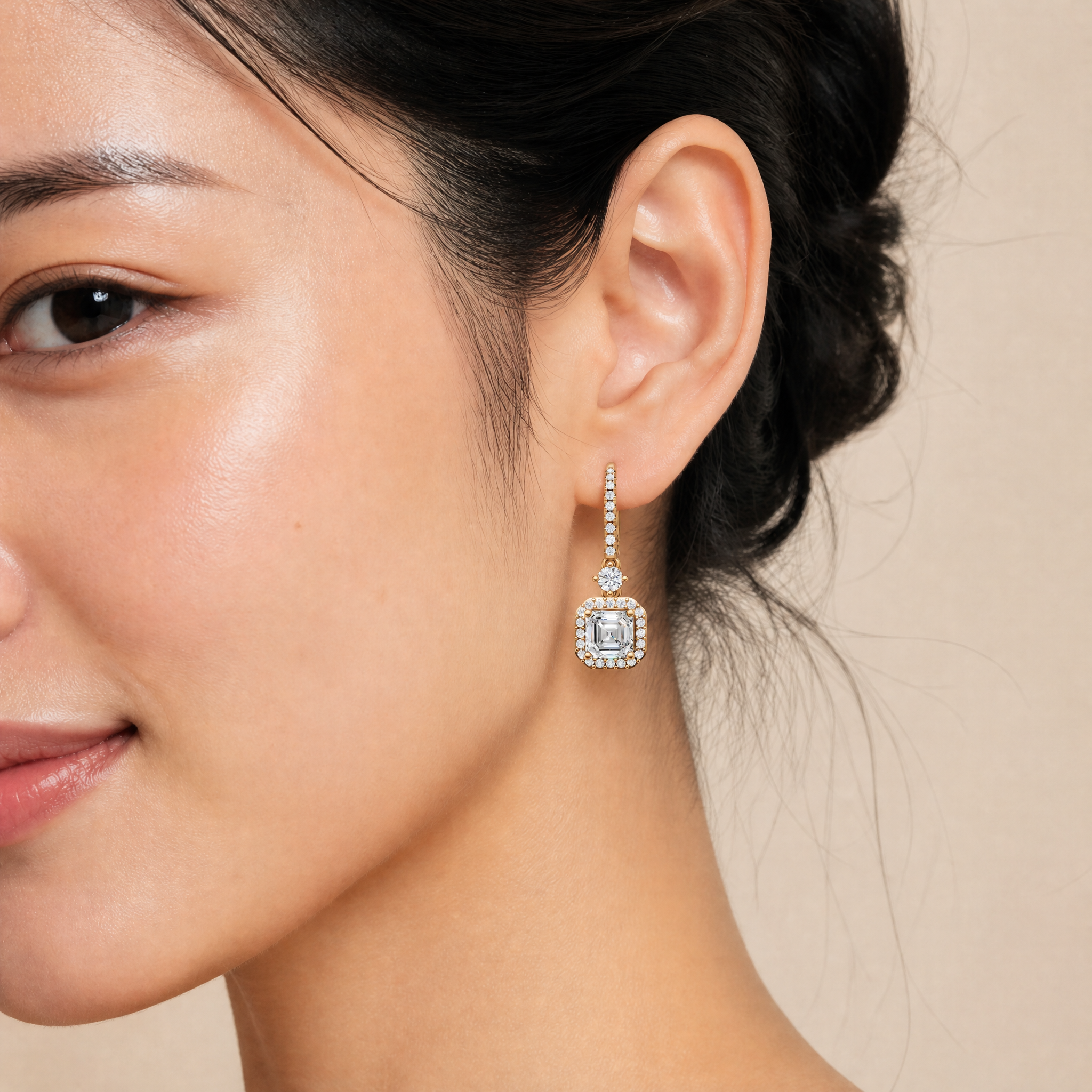 Elegant model wearing Raul Diamonds asscher cut halo diamond drop earrings with sparkling pave hoops