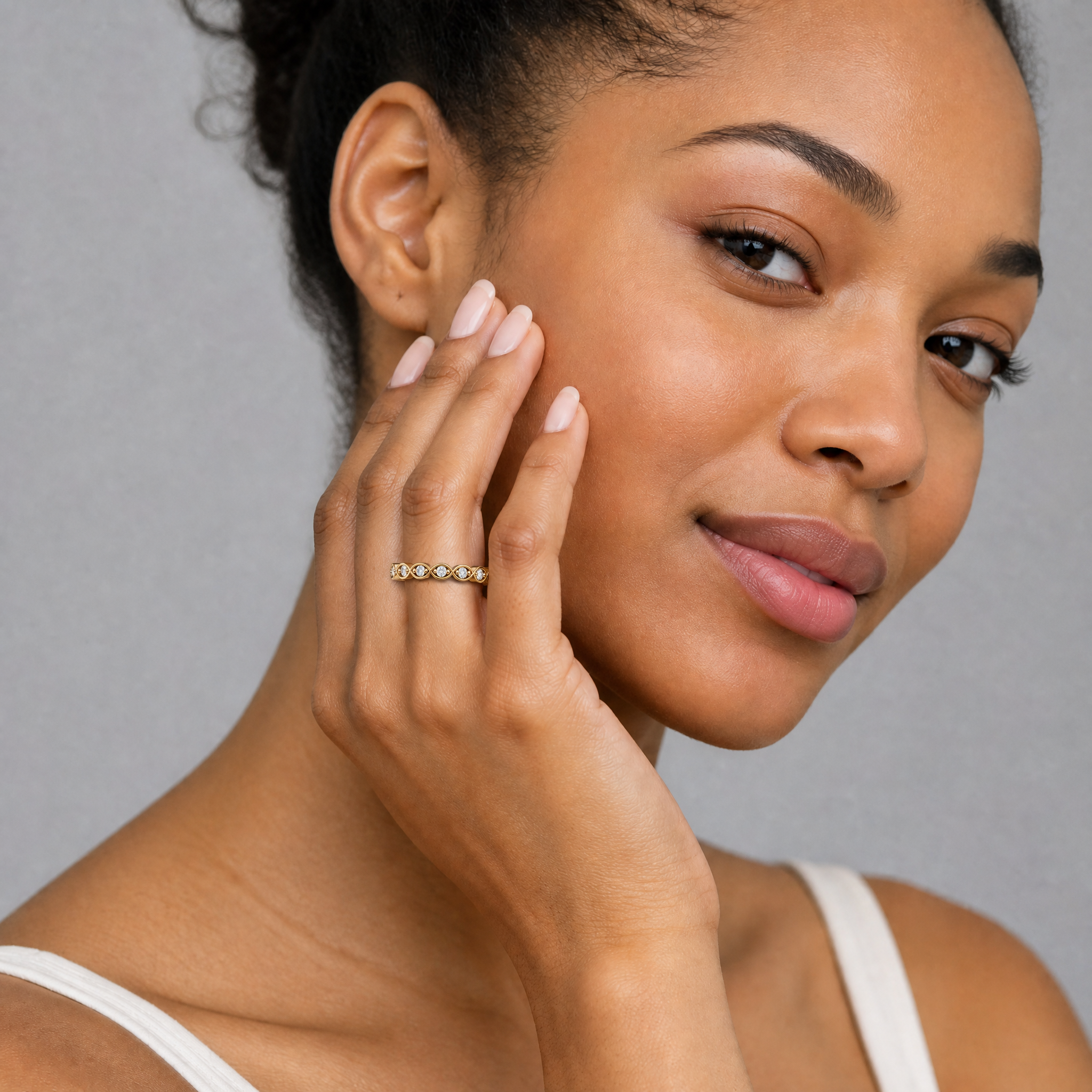 Female model wearing Raul Diamonds infinity diamond wedding band in yellow gold with round brilliant diamonds