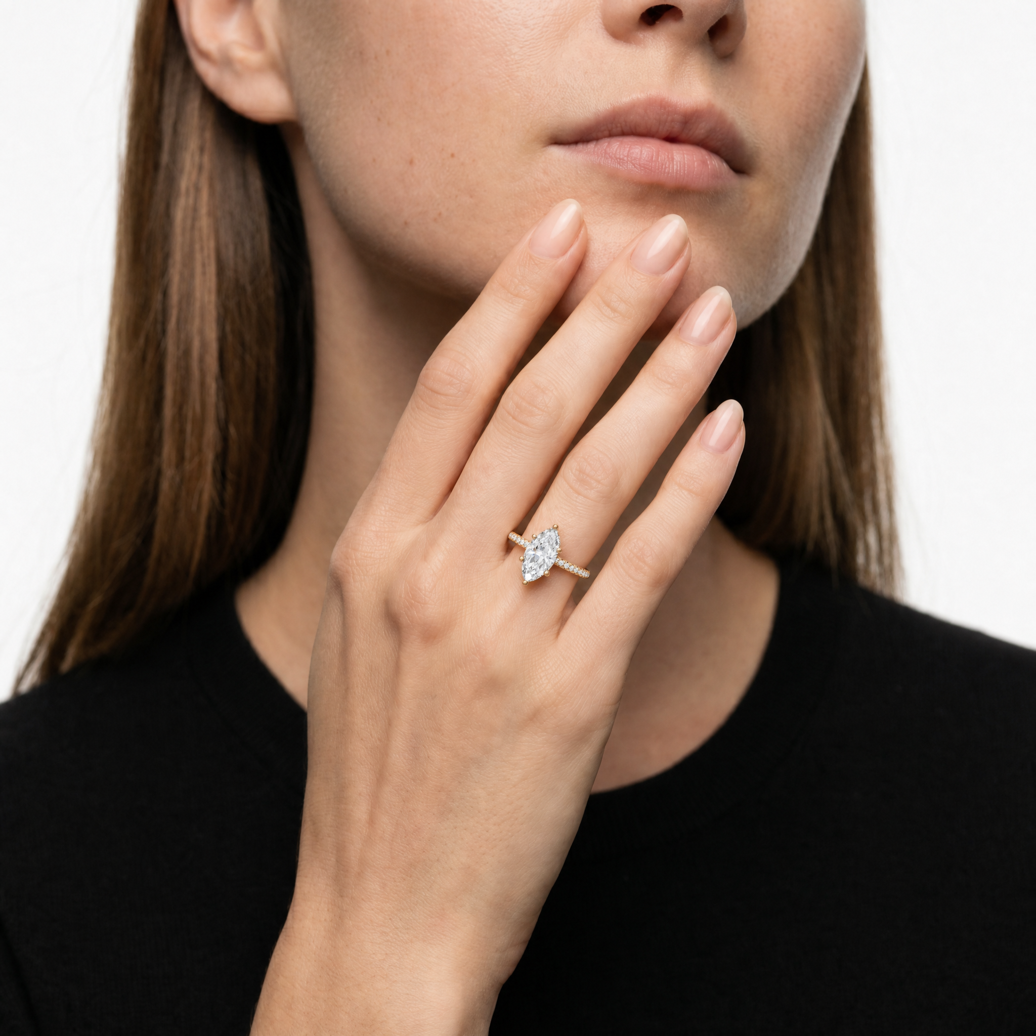 A luxury showcase of a Raul Diamonds marquise cut engagement ring on a model's hand, highlighting the elegant length of the diamond and the sparkling hidden halo detail.