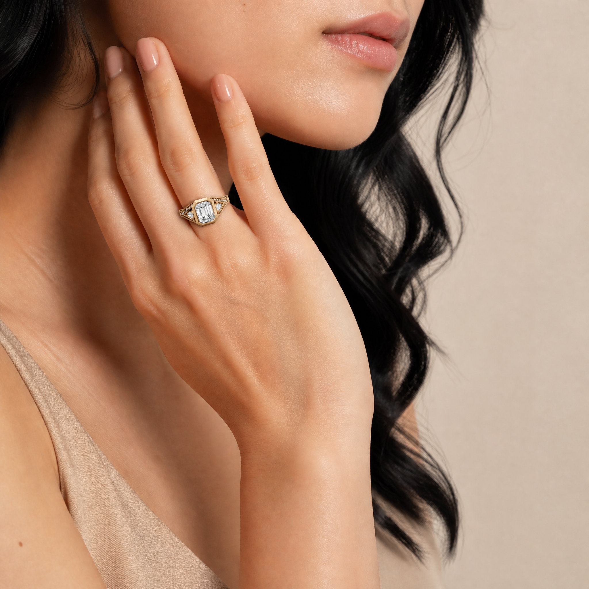 Model wearing Raul Diamonds emerald cut bezel set lab grown diamond engagement ring in yellow gold with pavé diamonds and elegant vintage inspired bridal detailing