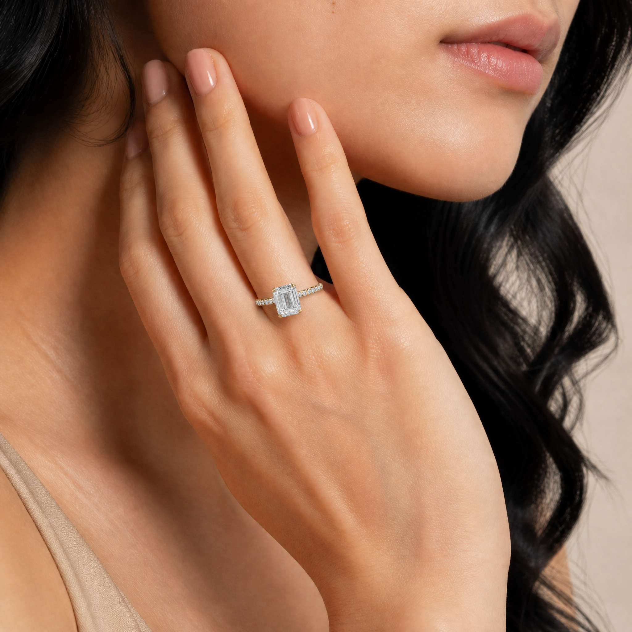 Model wearing Raul Diamonds emerald cut lab grown diamond engagement ring in yellow gold with a slim pavé diamond band and elegant modern bridal style
