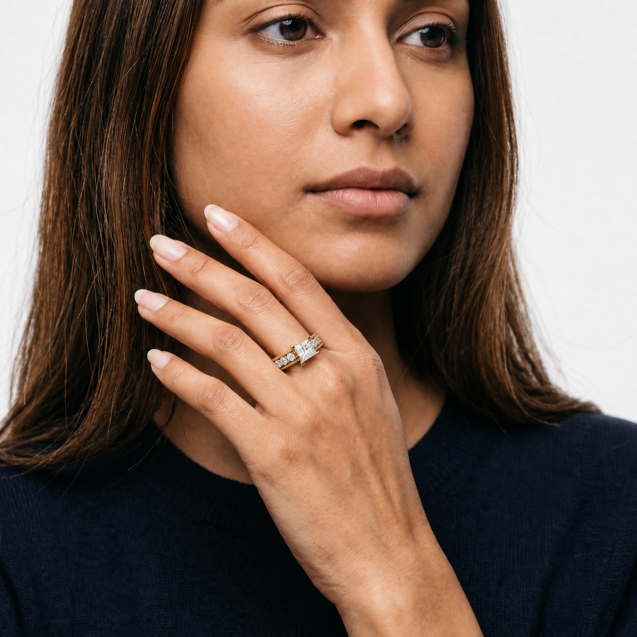 Elegant model wearing Raul Diamonds princess cut lab grown diamond engagement ring with pavé diamond detailing and vintage inspired yellow gold band for luxury bridal style