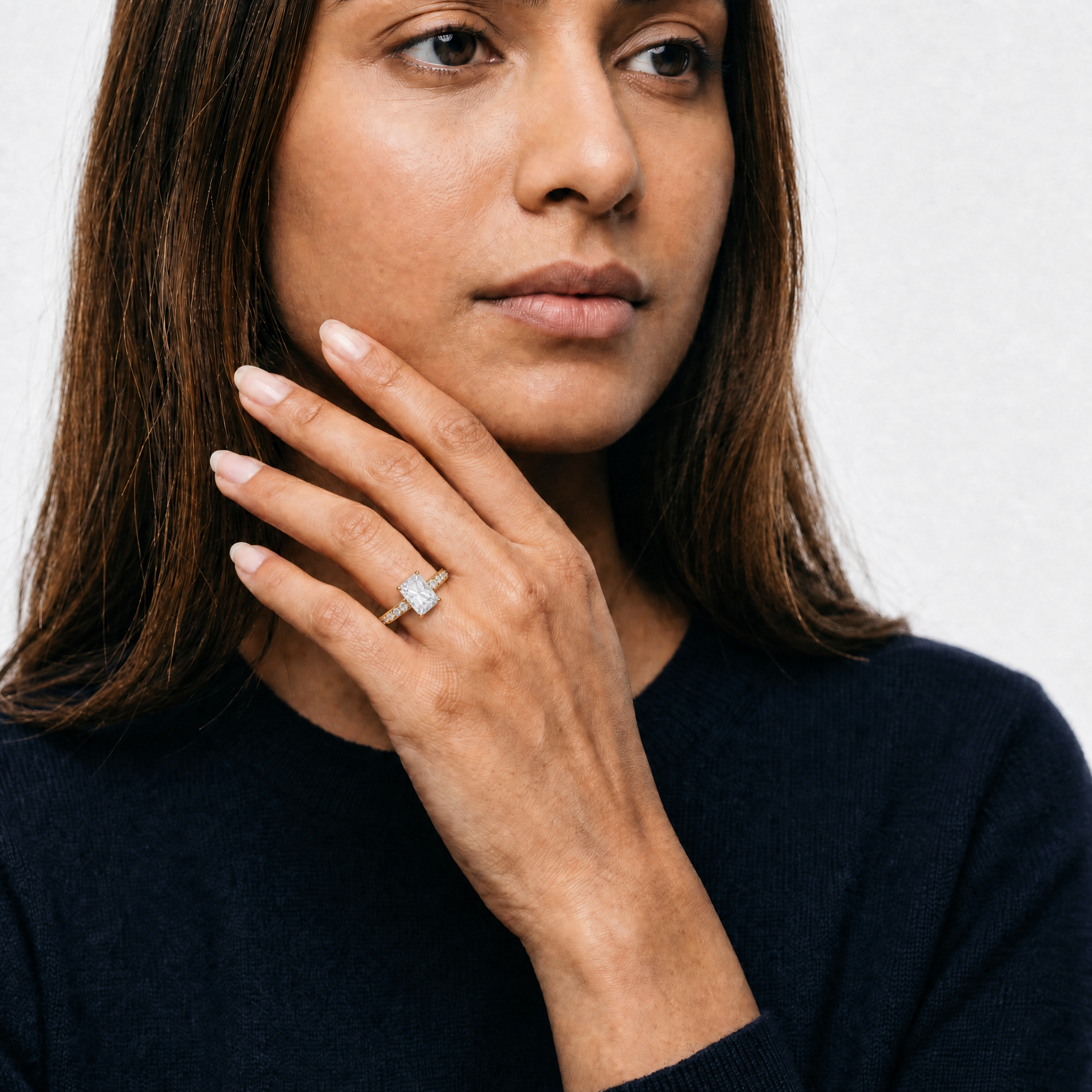 Model wearing Raul Diamonds radiant cut lab grown diamond engagement ring in yellow gold with a sparkling pavé diamond band and sophisticated luxury bridal style