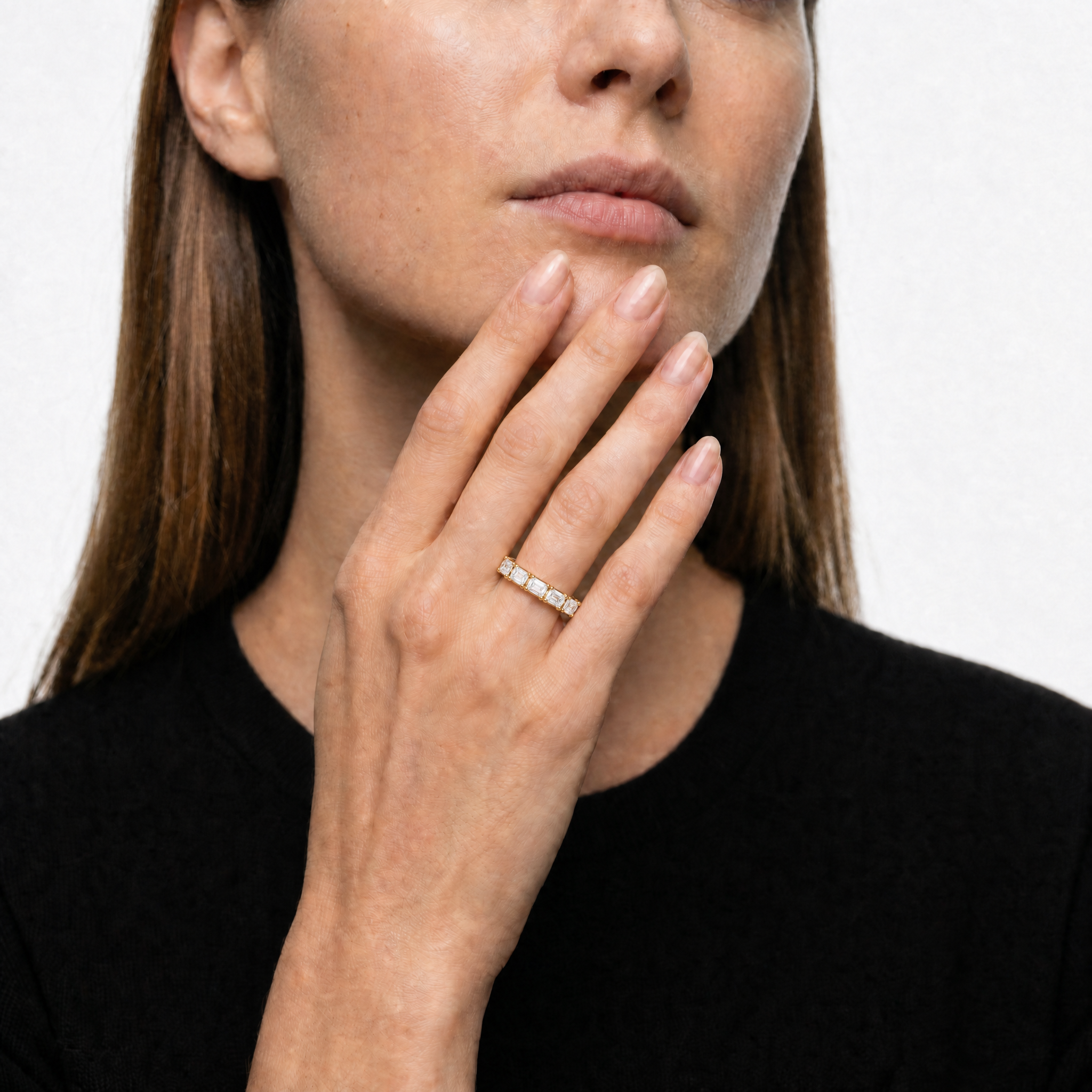 Model wearing Raul Diamonds yellow gold emerald cut lab grown diamond eternity band featuring elegant shared prong setting and timeless luxury wedding style for women