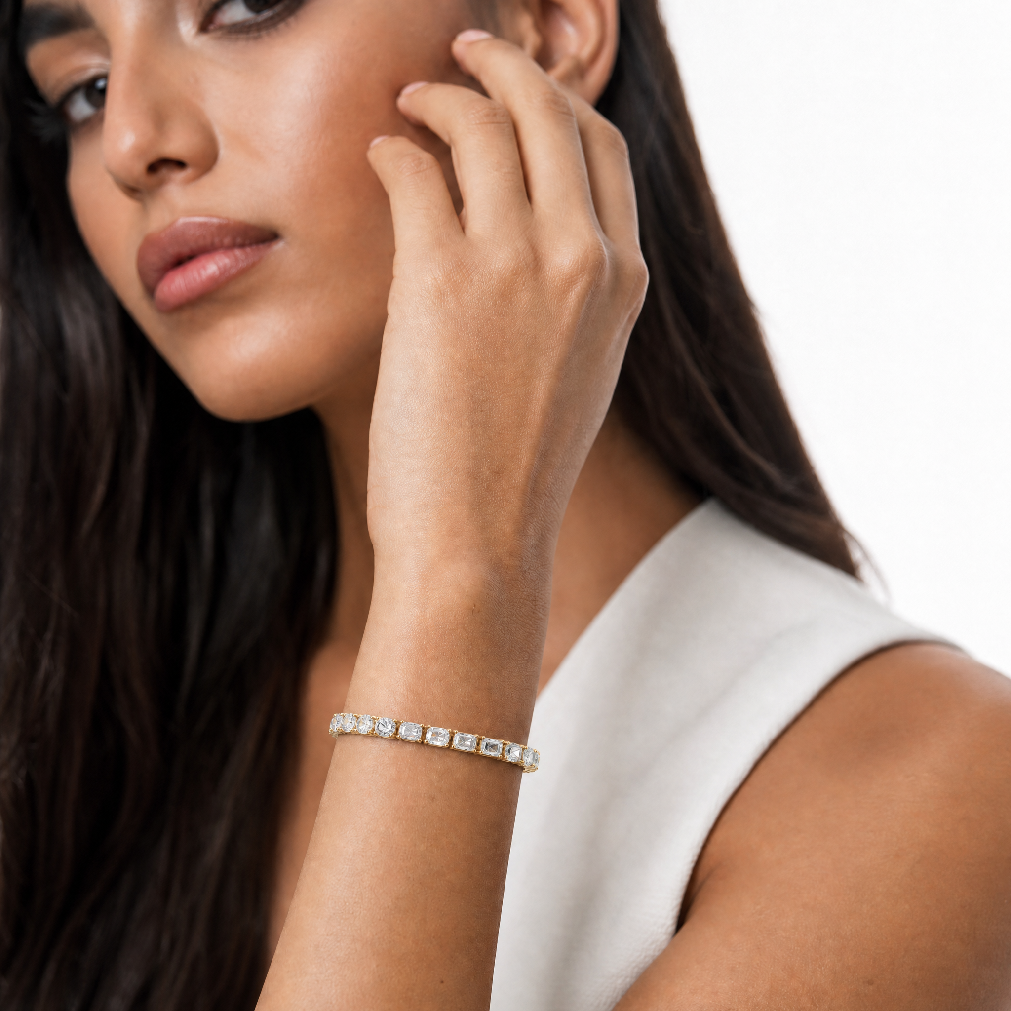 Model wearing Raul Diamonds yellow gold mixed shape lab grown diamond tennis bracelet featuring emerald cut and round brilliant diamonds in a luxury prong setting