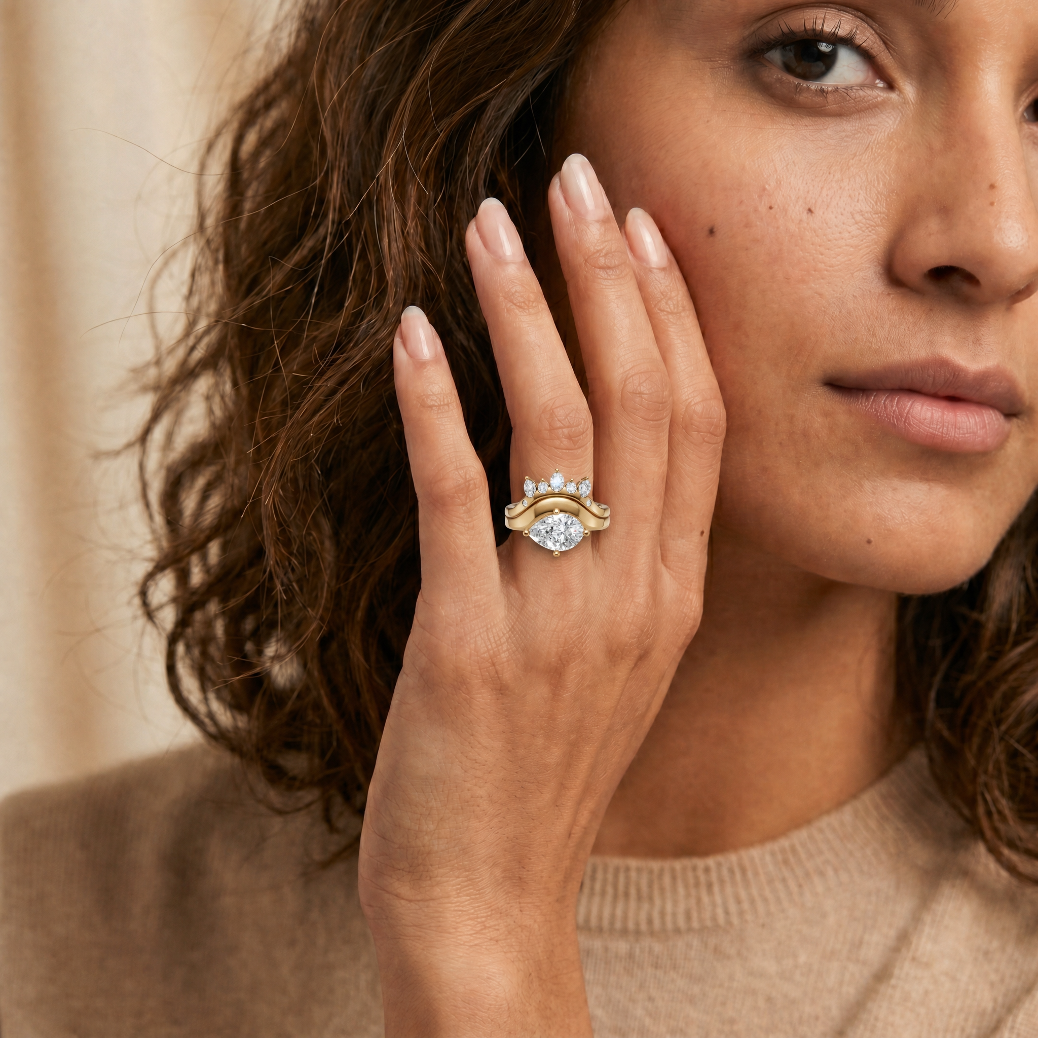 Model wearing Raul Diamonds yellow gold pear cut lab grown diamond engagement ring set with curved diamond wedding band and marquise side stone accents for women