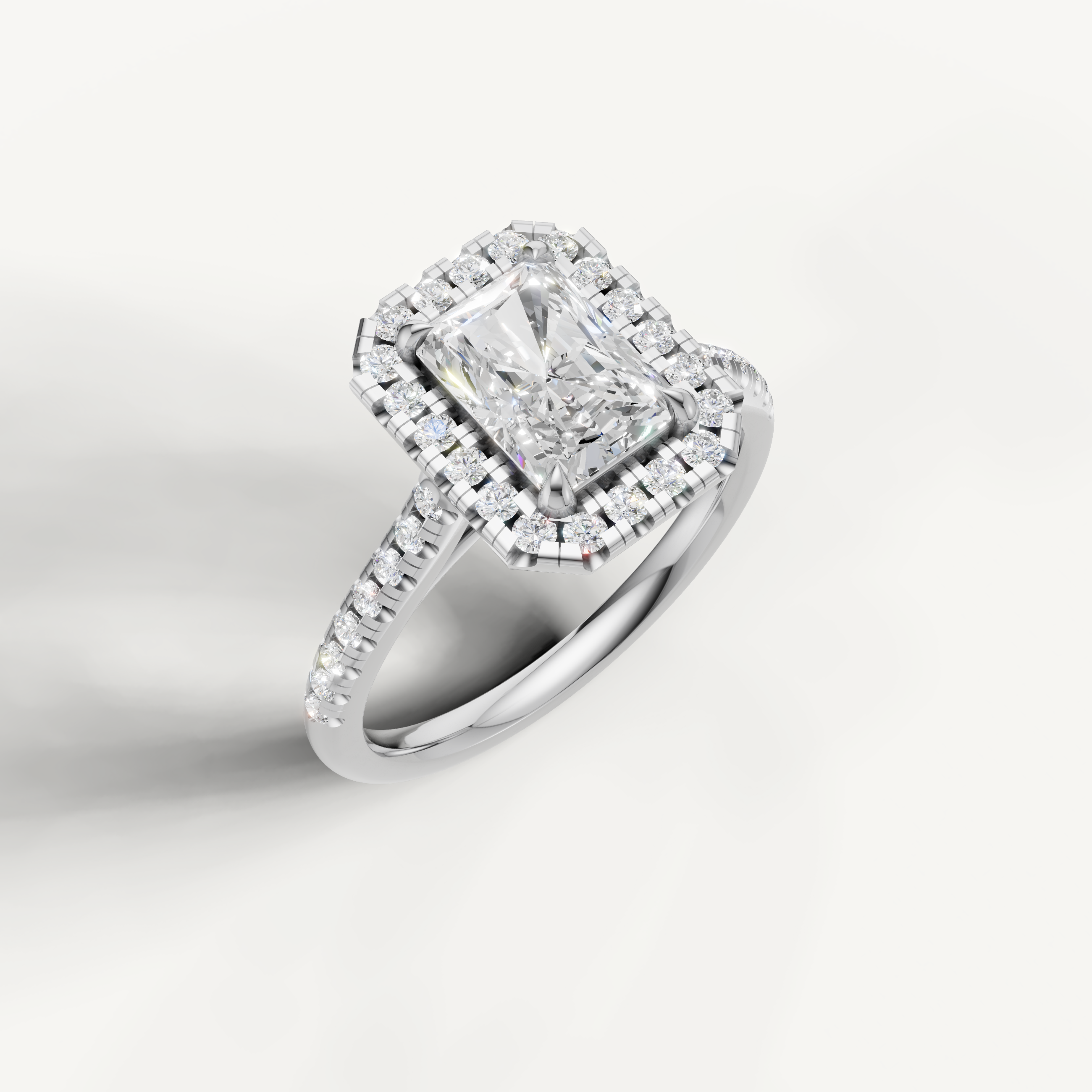 White gold radiant diamond halo ring featuring sparkling pavé details by Raul Diamonds