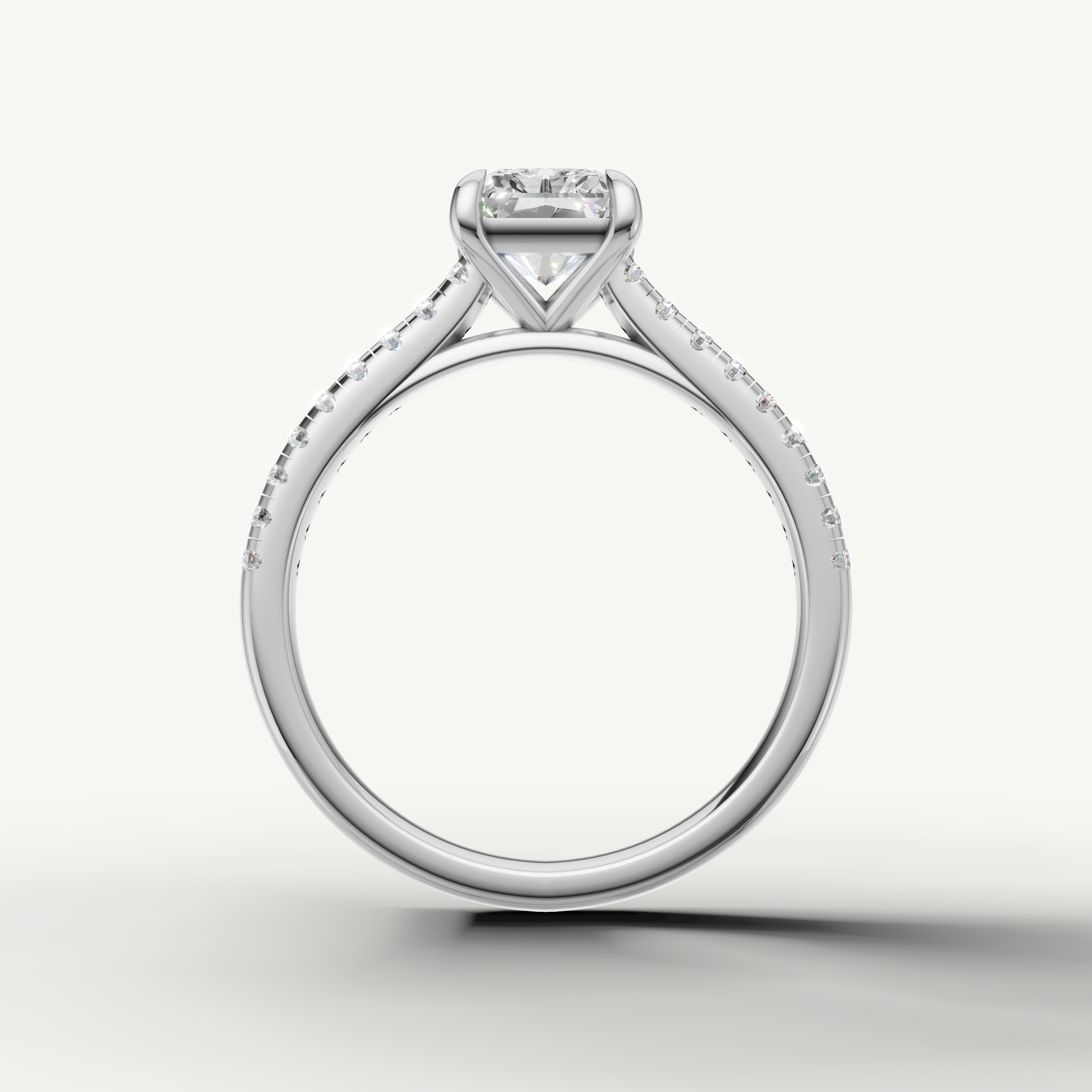 Elegant white gold radiant solitaire ring with diamond pavé band by Raul Diamonds