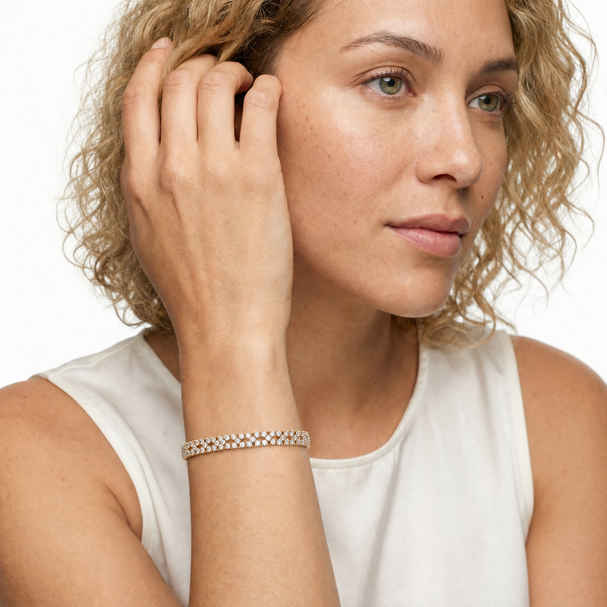Luxury female model wearing a floral lab grown diamond tennis bracelet in yellow gold by Raul Diamonds with elegant fine jewelry styling and timeless sparkle for modern women