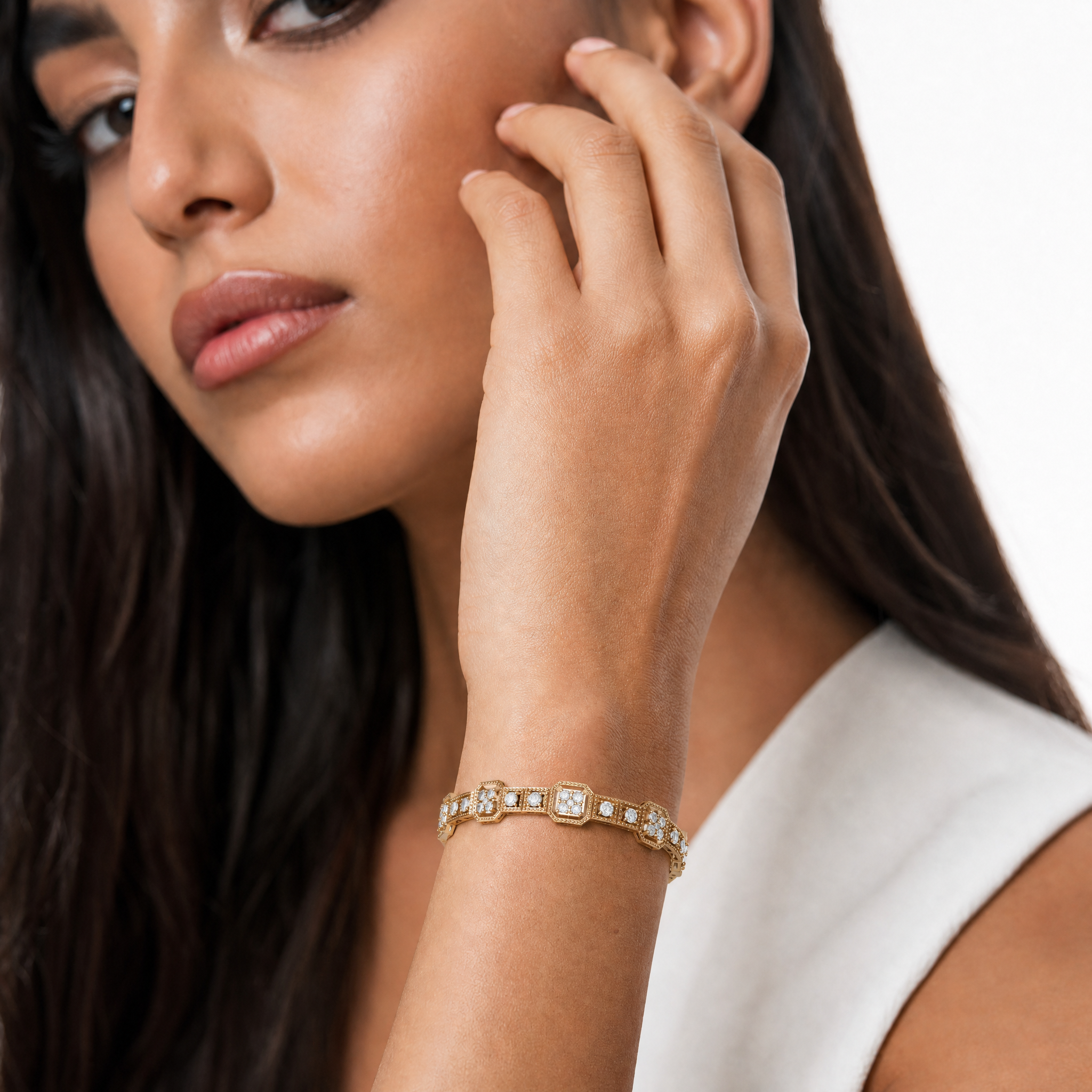 Elegant female model wearing a vintage-inspired yellow gold lab grown diamond bracelet by Raul Diamonds featuring geometric halo details and luxurious fine jewelry craftsmanship