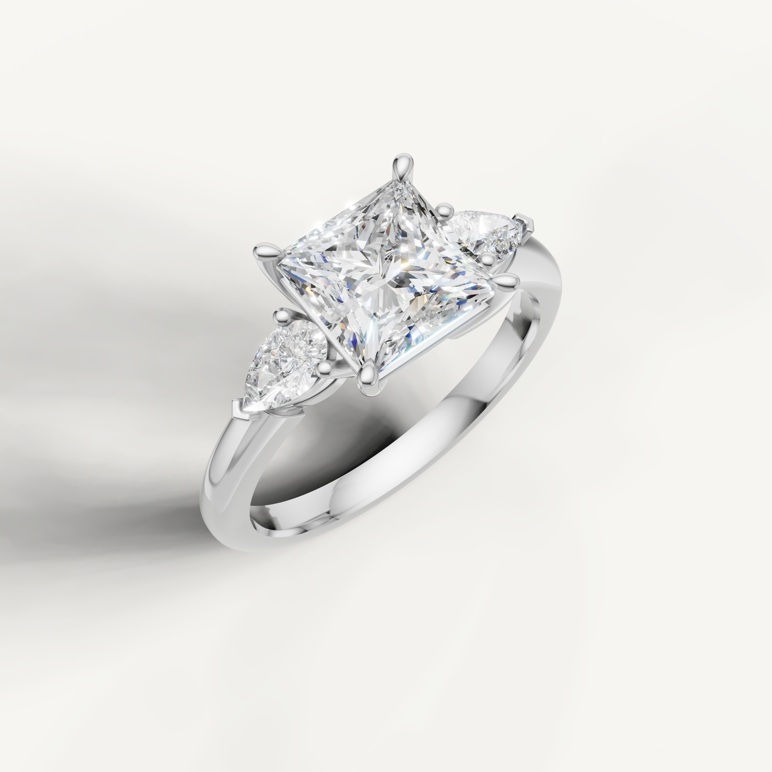classic princess cut lab grown diamond trilogy ring with pear shaped side stones
