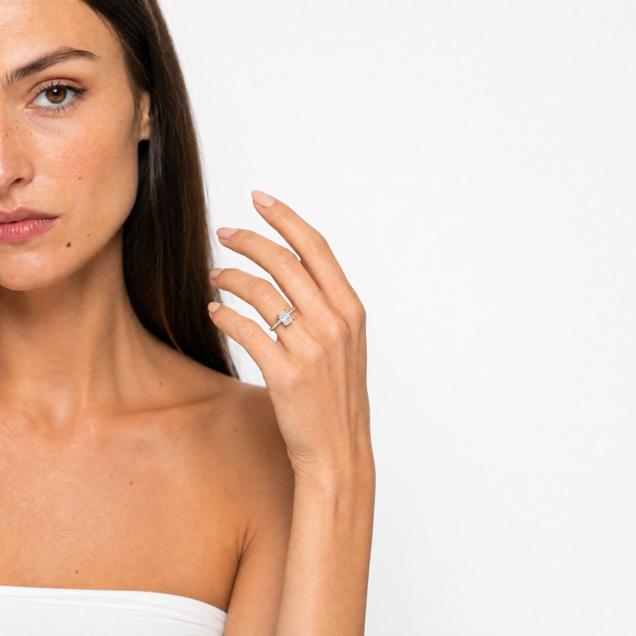 "Elegant hand model showcasing a Raul Diamonds radiant-cut diamond engagement ring, highlighting the 'crushed ice' sparkle of the center stone and the delicate diamond pavé band against a luxury backdrop."