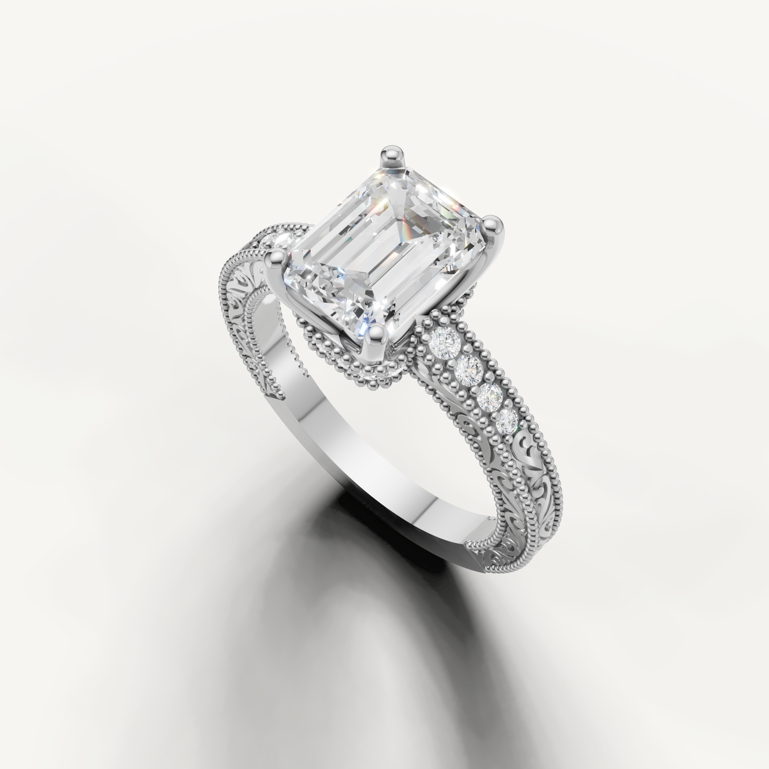 Elegant emerald diamond engagement ring in white gold with vintage floral engraving and pavé detailing by Raul Diamonds.