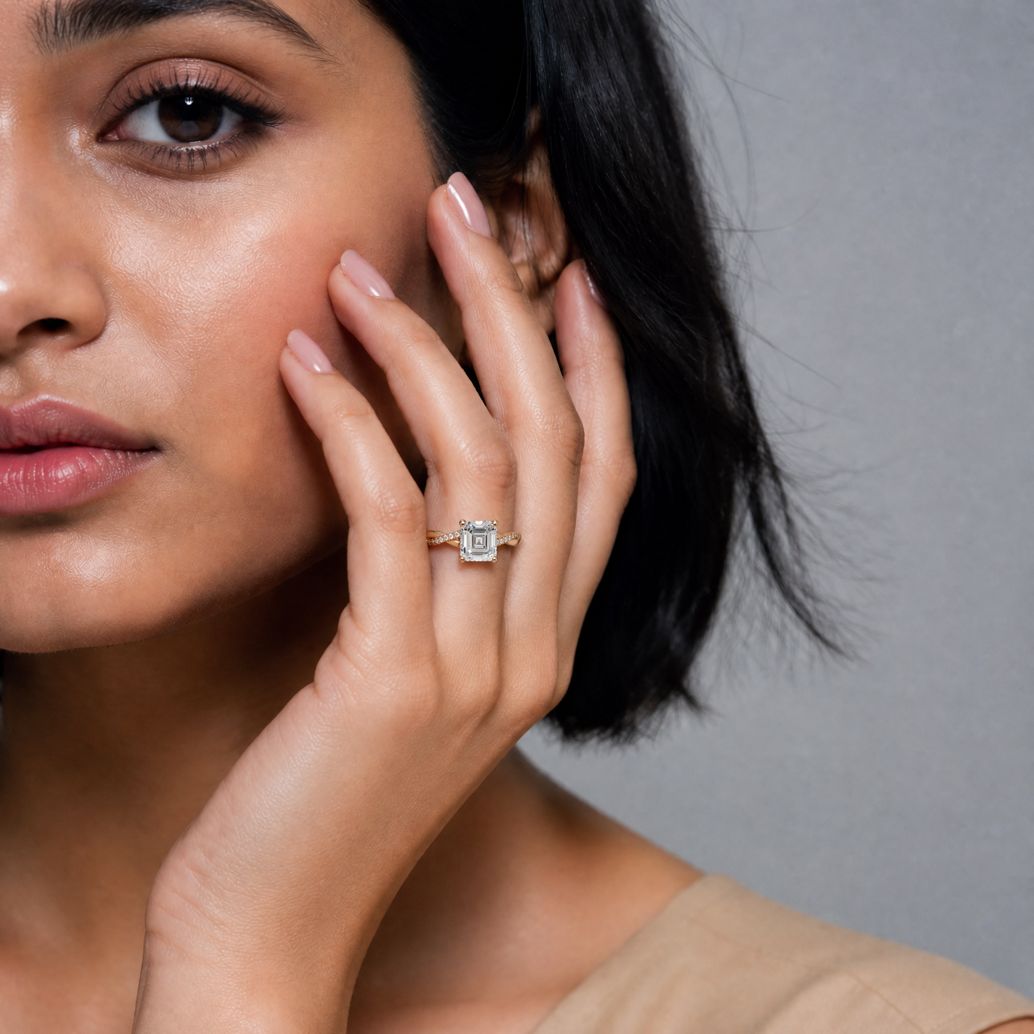 Close-up shot of a model wearing a Raul Diamonds Asscher cut diamond engagement ring with a twisted pavé band, showcasing the brilliant step-cut facets and elegant metal craftsmanship.