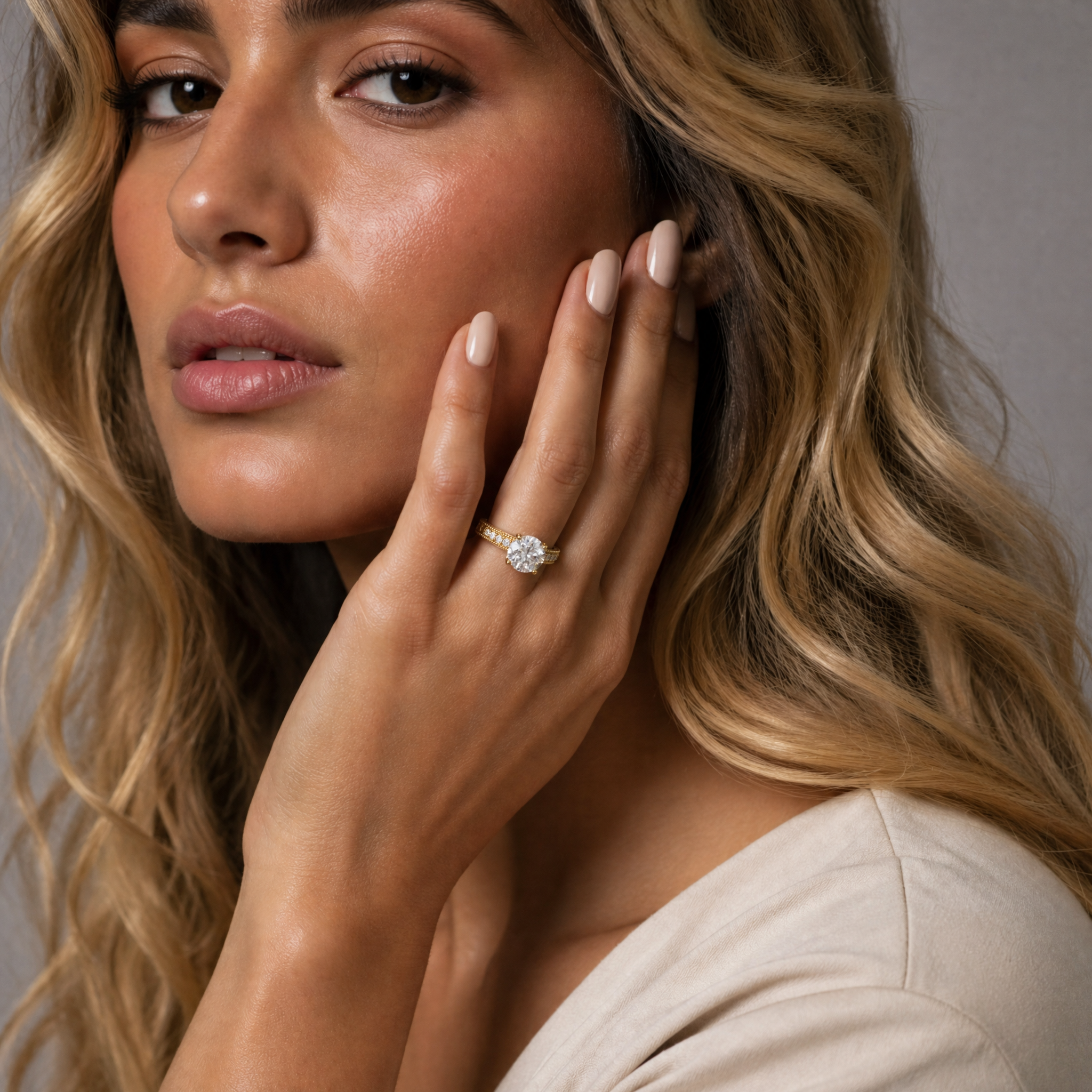 Model wearing a vintage-inspired round cut lab grown diamond engagement ring in 14K yellow gold by Raul Diamonds featuring ornate milgrain detailing and pavé accents.