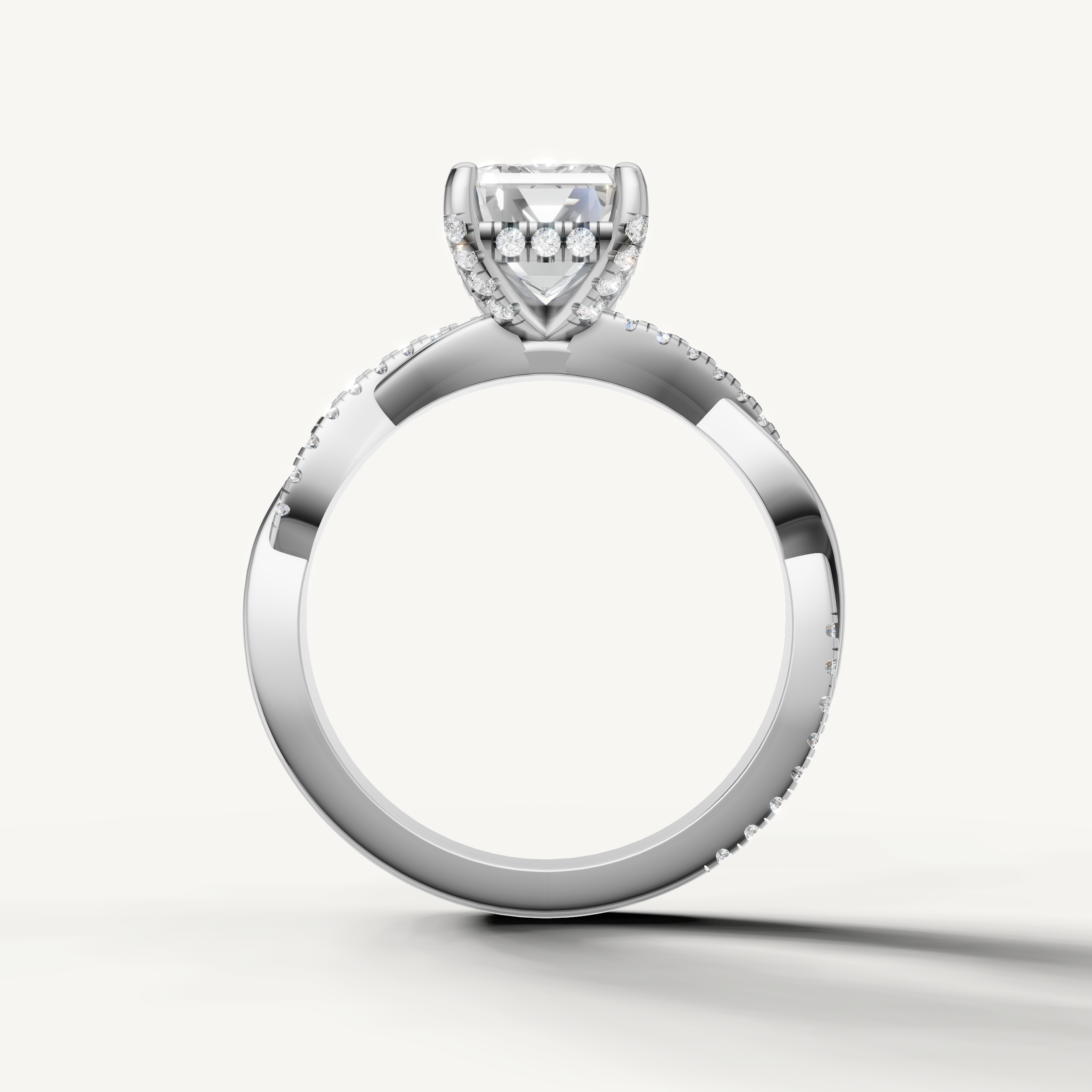 Luxury white gold emerald cut diamond bridal jewelry with a pavé-set intertwined band by Raul Diamonds