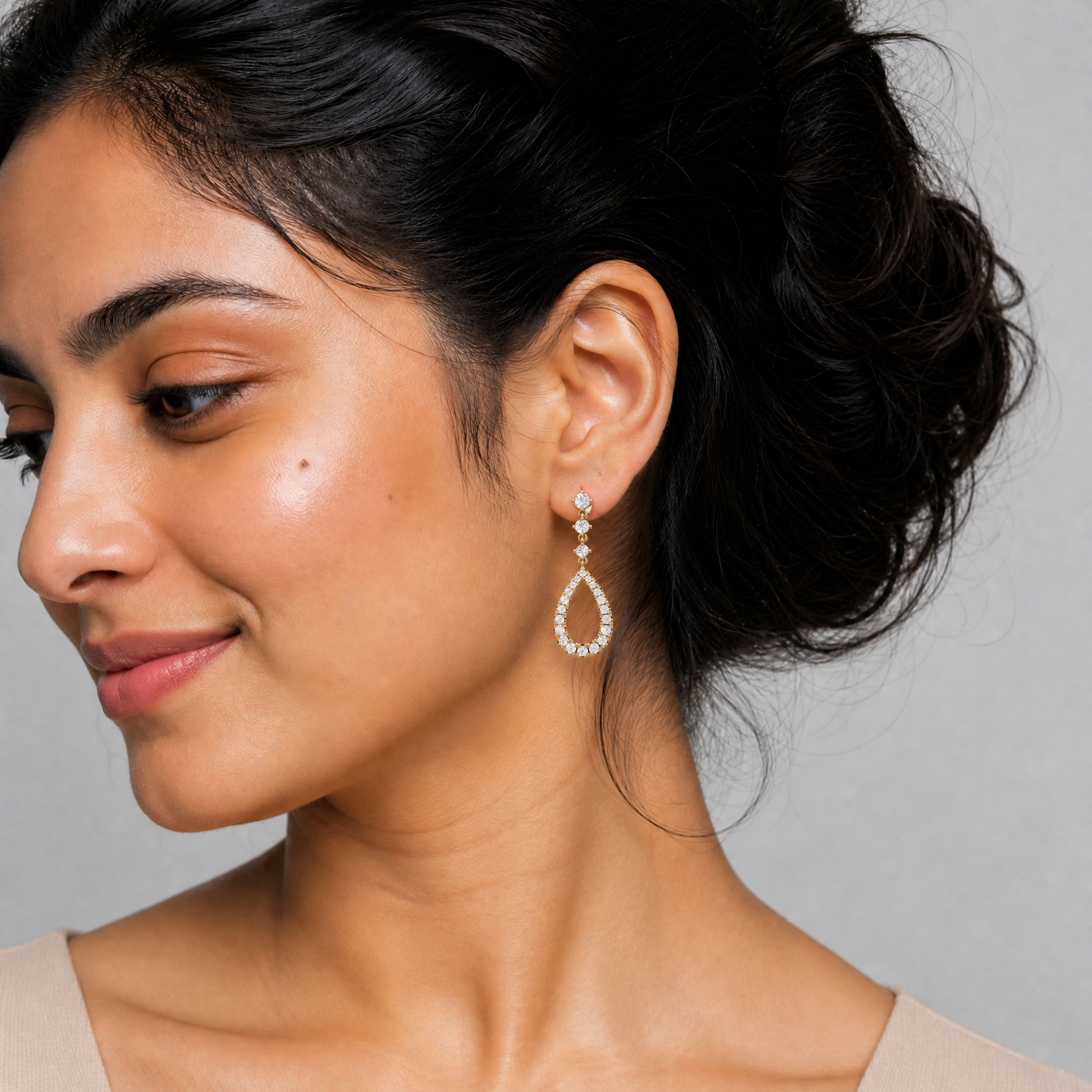 Model wearing Raul Diamonds luxury diamond teardrop drop earrings in gold finish