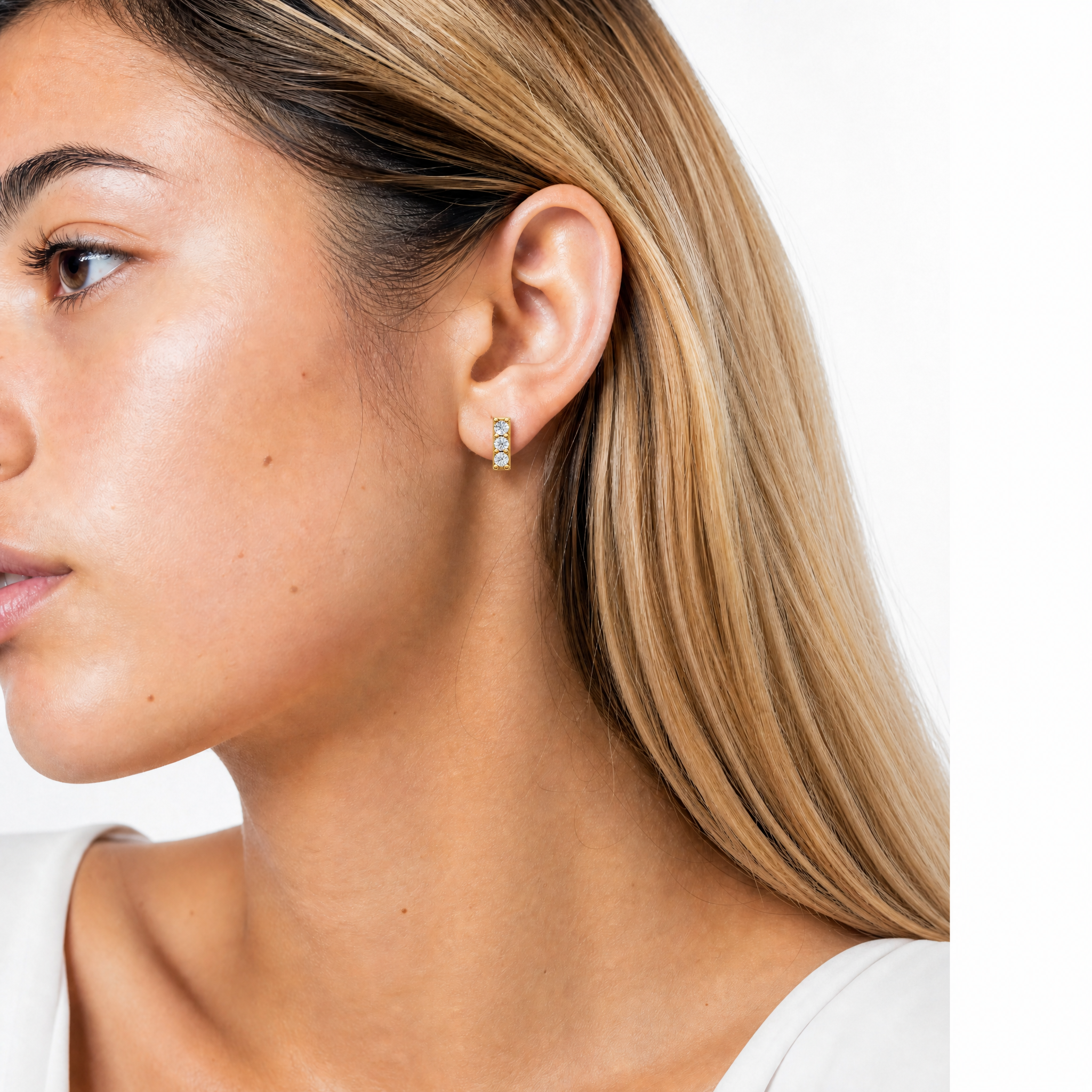 Model wearing Raul Diamonds yellow gold three stone diamond bar stud earrings with luxury styling