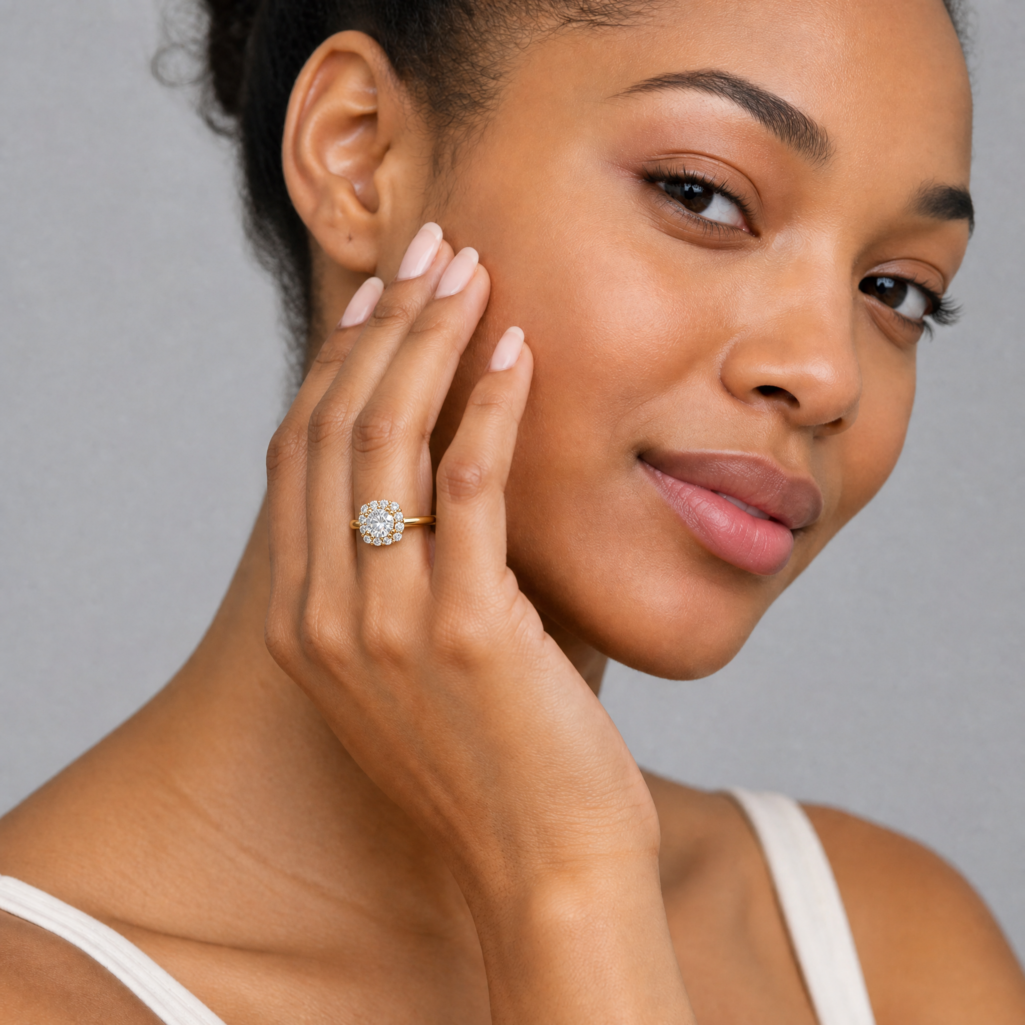 Woman wearing Raul Diamonds round halo engagement ring with floral inspired diamond setting.