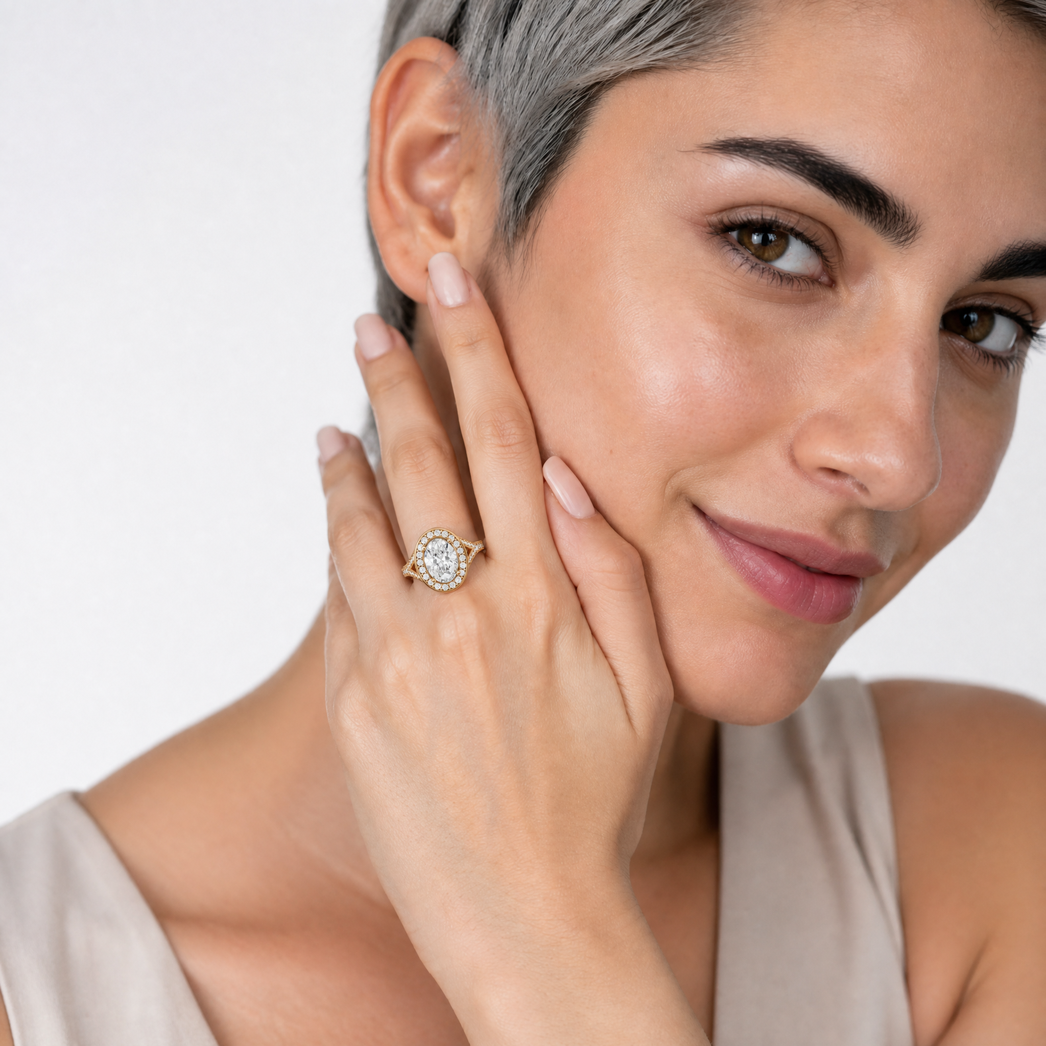 Woman wearing Raul Diamonds oval halo engagement ring with pavé split shank band.