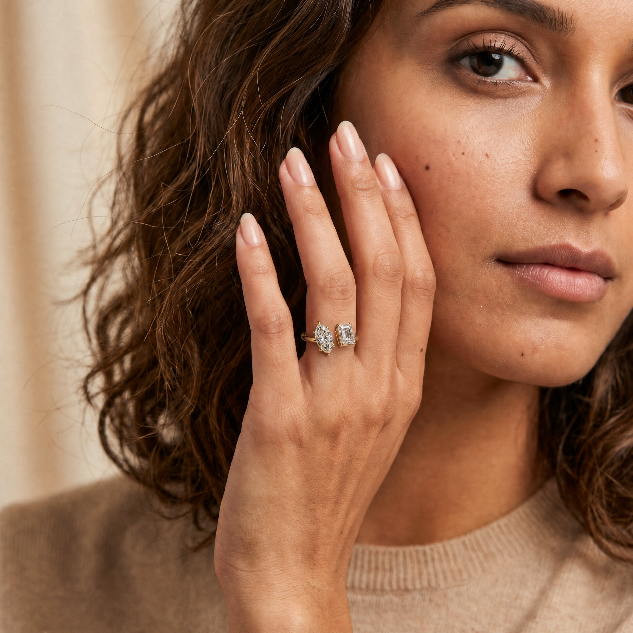Female model wearing Raul Diamonds toi et moi engagement ring with marquise and emerald cut diamonds in yellow gold