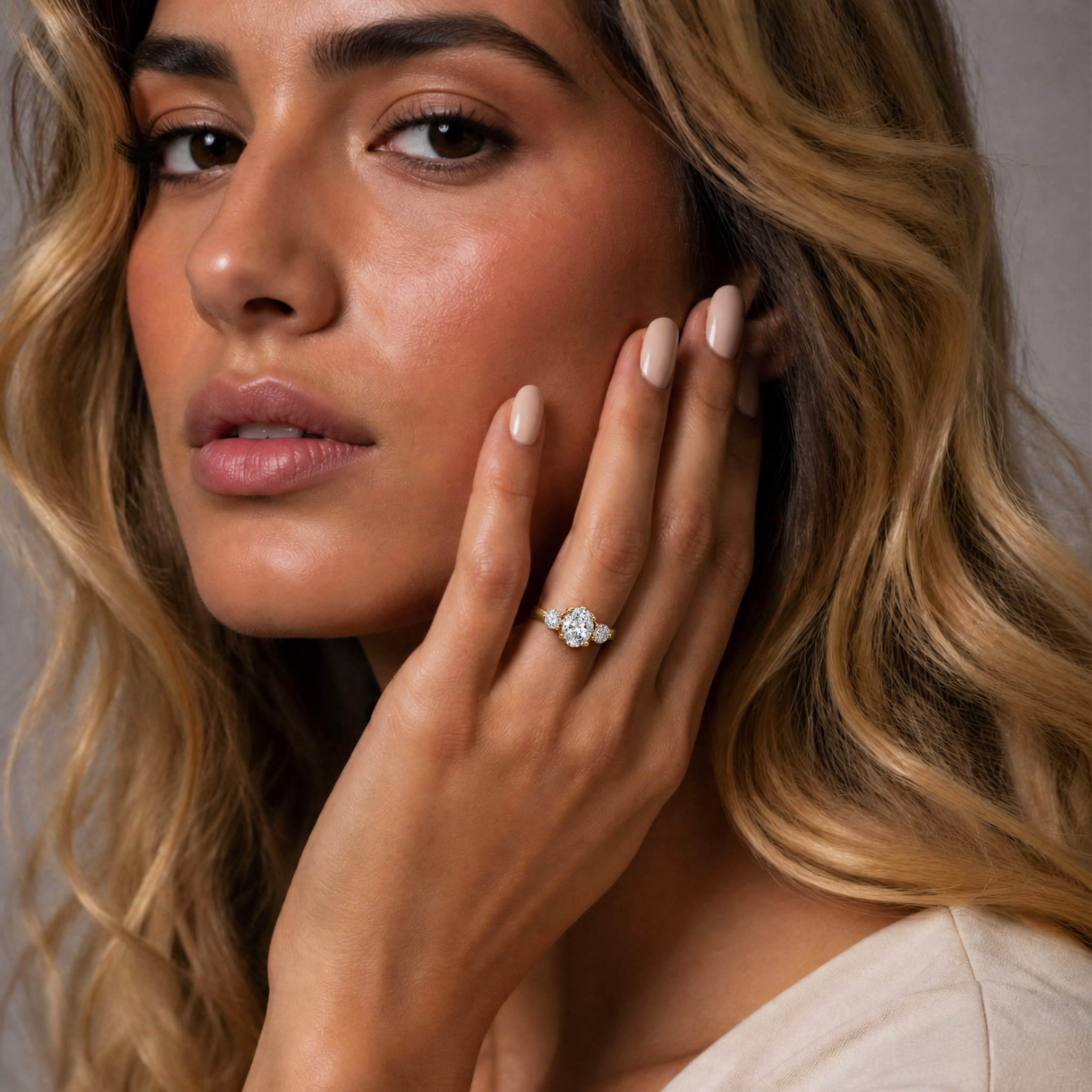 Model wearing Raul Diamonds oval cut diamond engagement ring in yellow gold with side stones