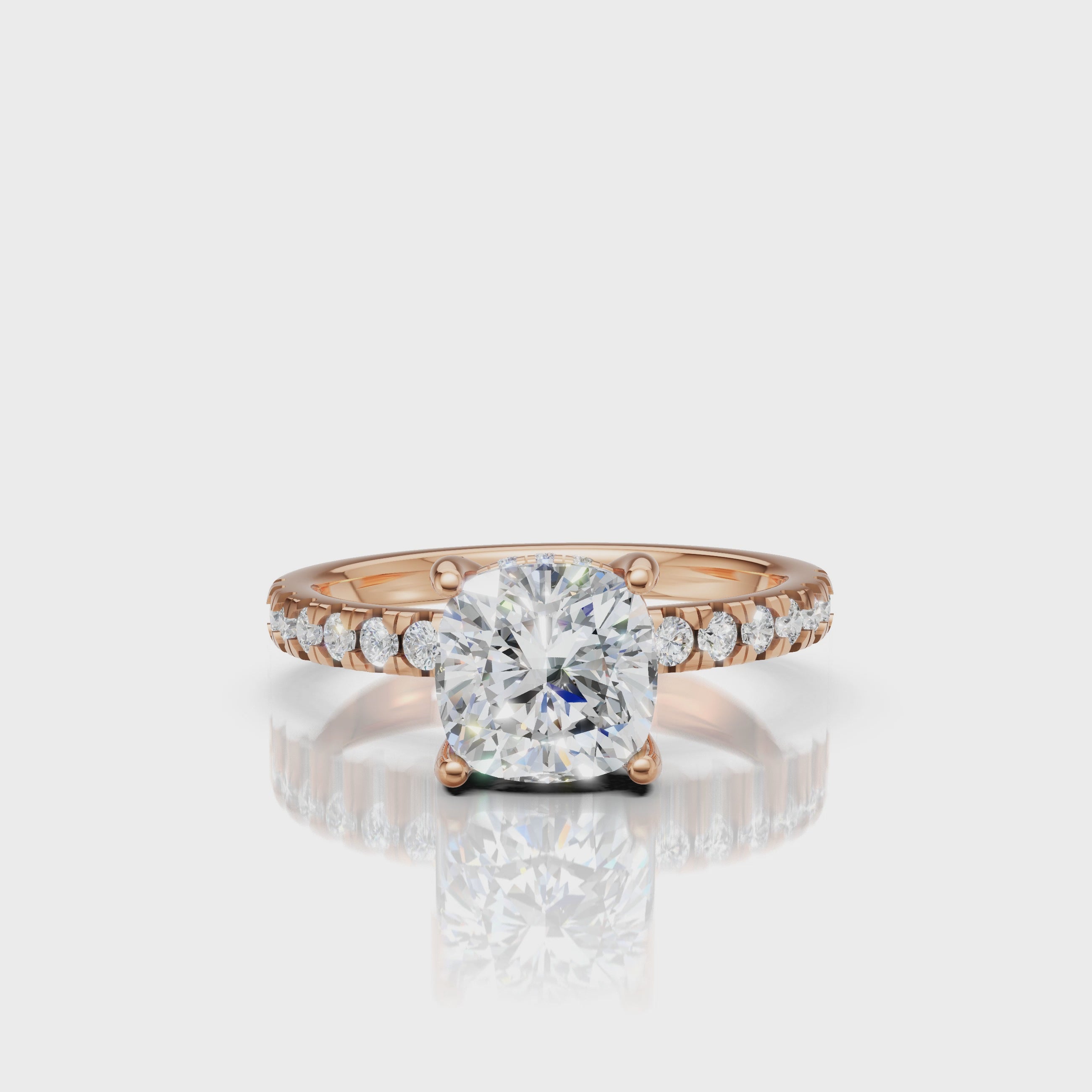 Cinematic 360-degree rotation of a rose gold cushion-cut diamond ring, capturing the warm romantic metal tones and the brilliant fire of the cushion facets