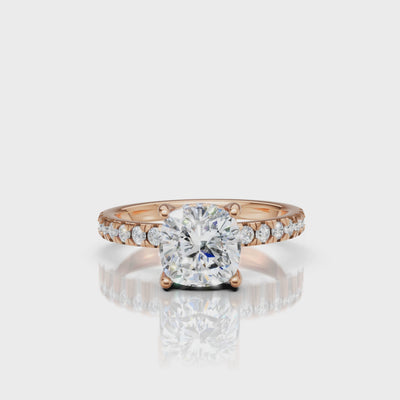 Cinematic 360-degree rotation of a rose gold cushion-cut diamond ring, capturing the warm romantic metal tones and the brilliant fire of the cushion facets