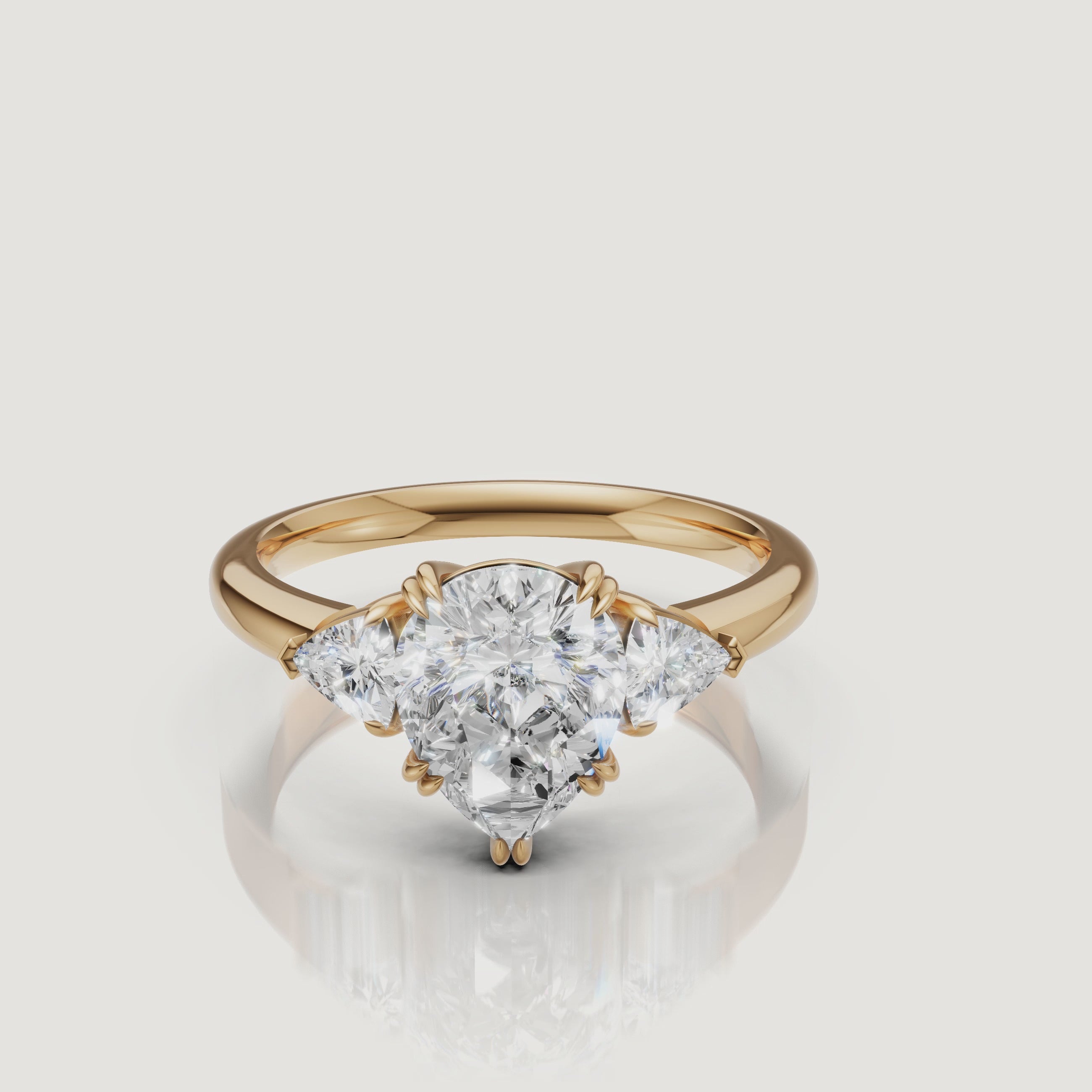 video of pear cut lab grown diamond engagement ring with trillion side stones in 14k yellow gold