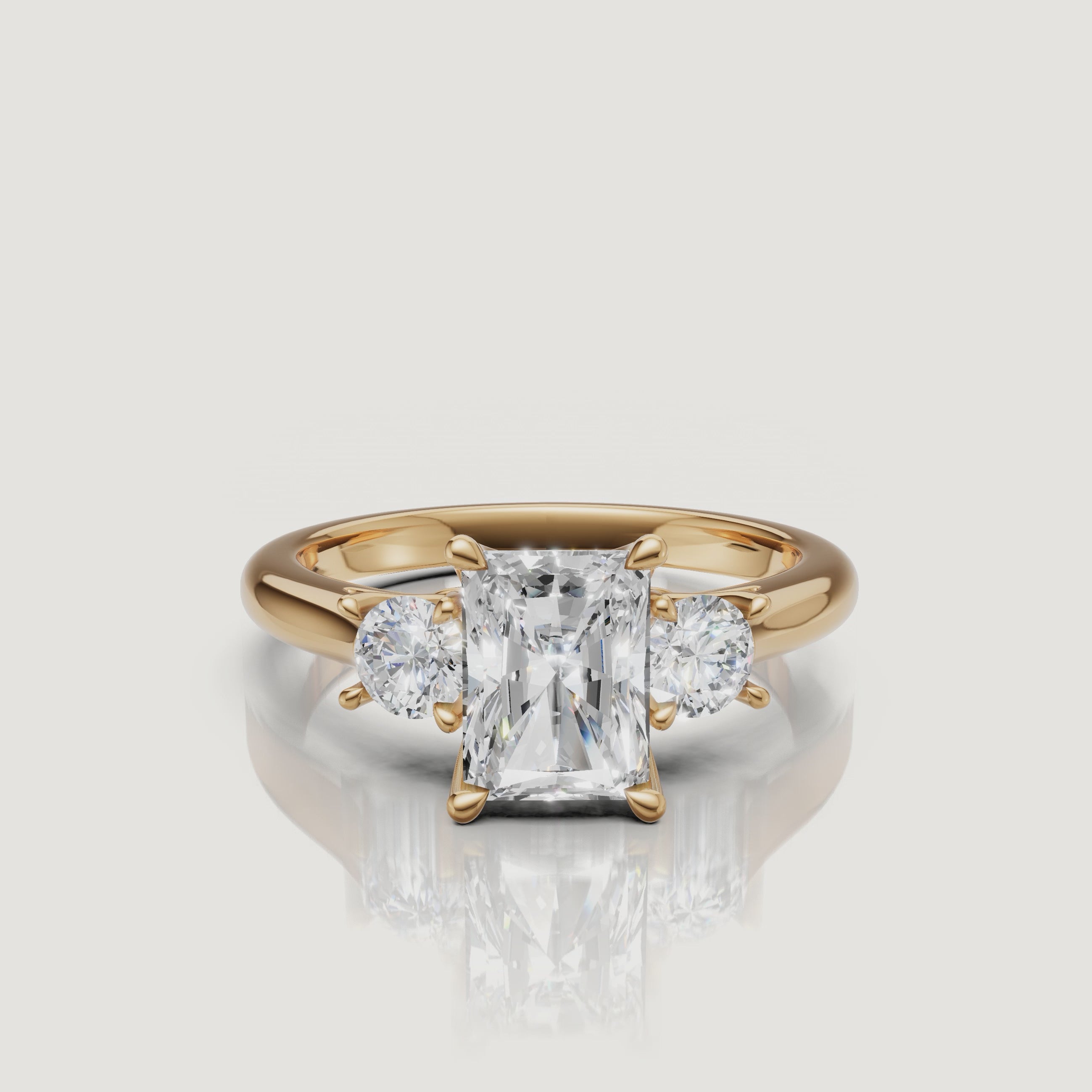 360-degree video showcase of the Raul Diamonds radiant cut three-stone ring in yellow gold, highlighting the crushed ice sparkle of the center stone and sharp cadillac side accents.