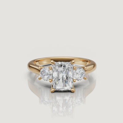 360-degree video showcase of the Raul Diamonds radiant cut three-stone ring in yellow gold, highlighting the crushed ice sparkle of the center stone and sharp cadillac side accents.