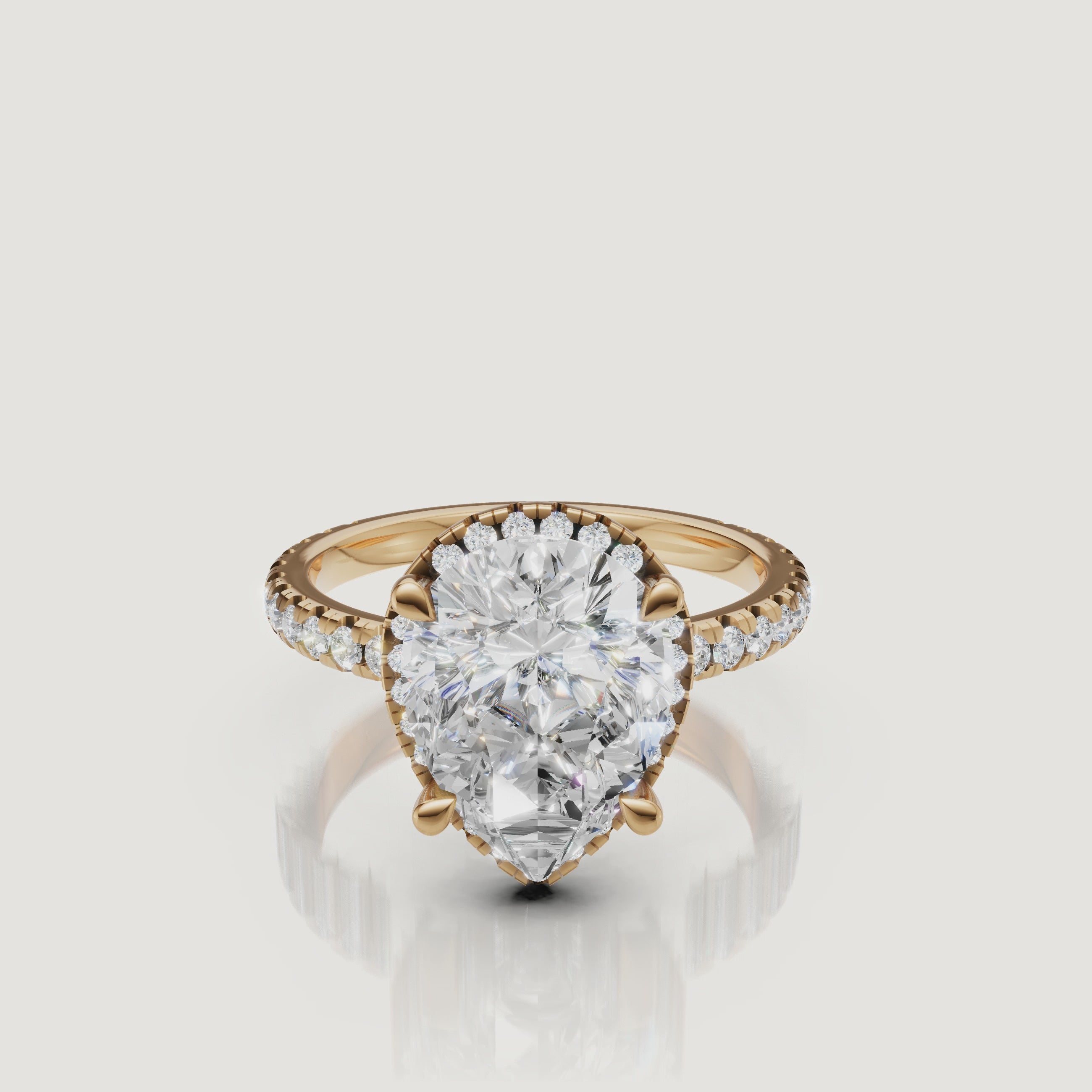 Cinematic 4K video of a Raul Diamonds Pear Cut Hidden Halo ring in 18k yellow gold, featuring a 360-degree rotation of the pavé diamond band