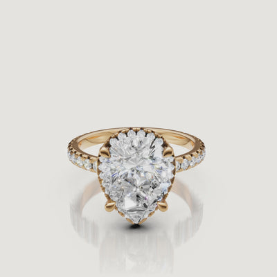 Cinematic 4K video of a Raul Diamonds Pear Cut Hidden Halo ring in 18k yellow gold, featuring a 360-degree rotation of the pavé diamond band