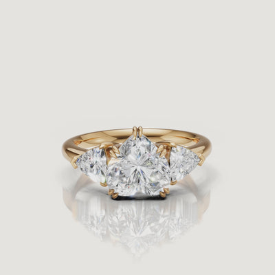 Cinematic 360-degree video showcase of a Raul Diamonds heart-cut diamond ring in 14k yellow gold, highlighting the sparkle of the trillion-cut side stones