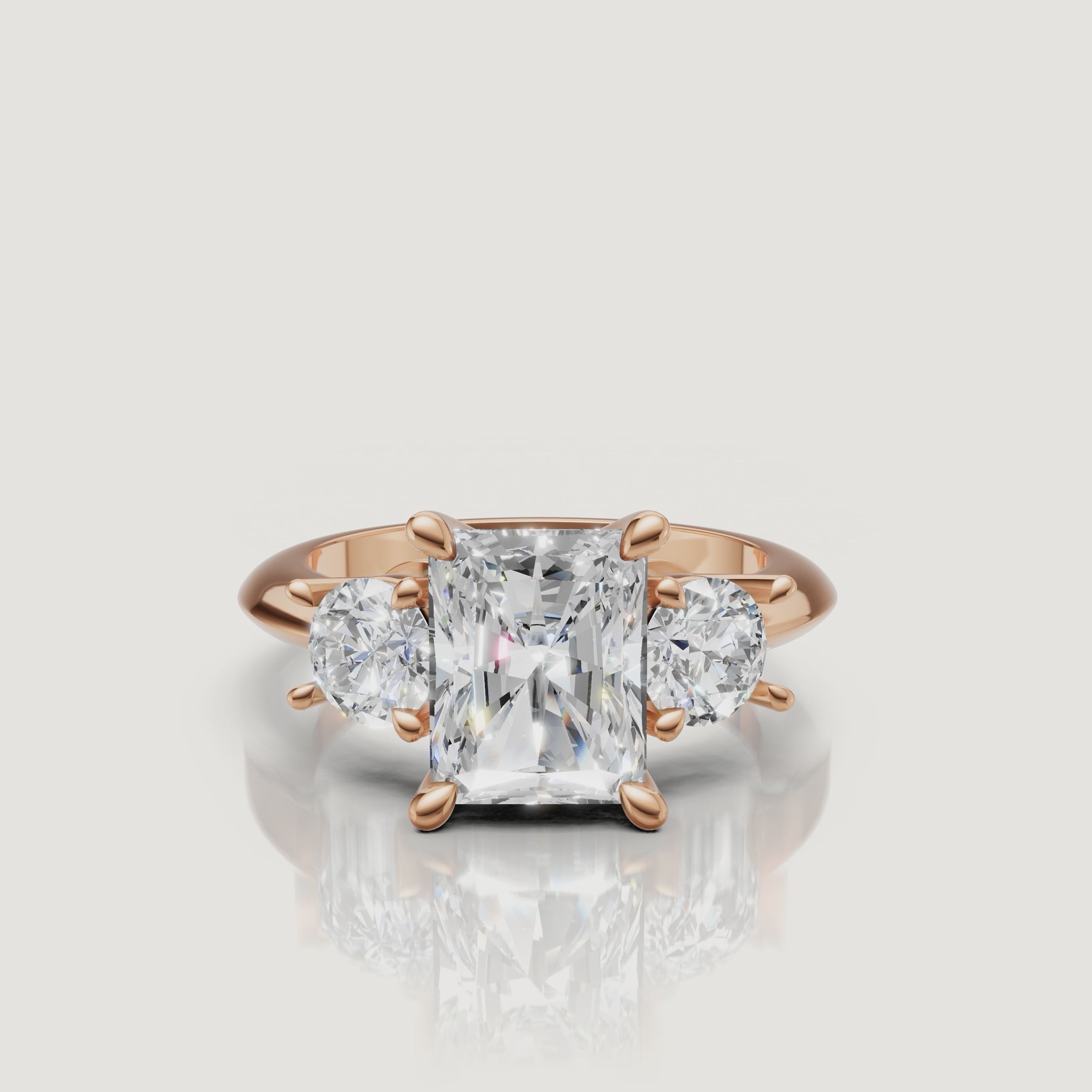 Cinematic close-up of the Isabella rose gold radiant trilogy ring, focusing on the warm blush metal and the exceptional light return of the radiant-shaped center diamond.