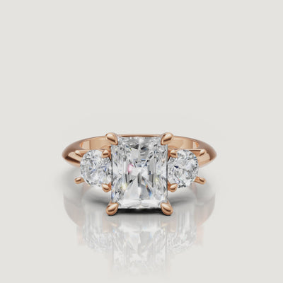 Cinematic close-up of the Isabella rose gold radiant trilogy ring, focusing on the warm blush metal and the exceptional light return of the radiant-shaped center diamond.