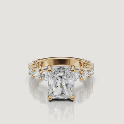Side-profile video of a Raul Diamonds radiant-cut diamond ring in 18k yellow gold, highlighting the intricate scalloped basket and shared-prong eternity diamonds